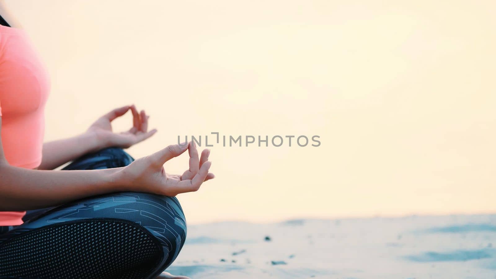 Healthy, young beautiful woman meditating, practicing yoga on the beach, by the sea, at sunrise, Relaxes muscles, mind, acquires the harmony of soul and body. close up. High quality photo