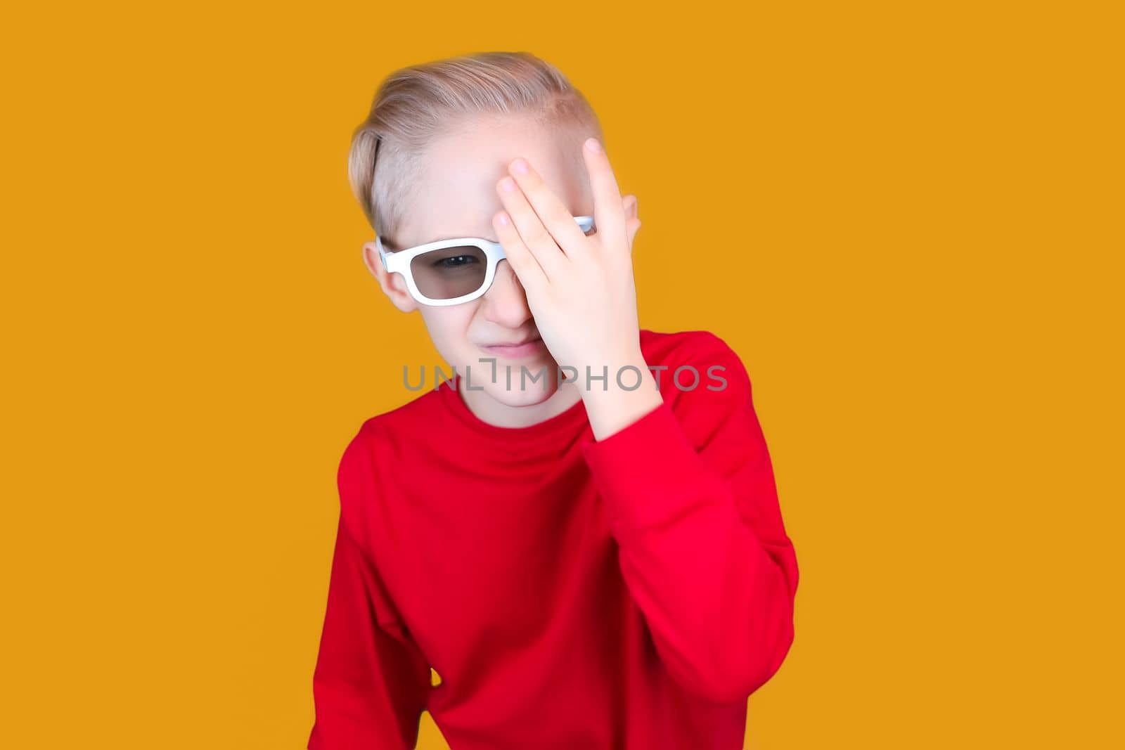 a child in children's 3D glasses covered his eyes with his hand