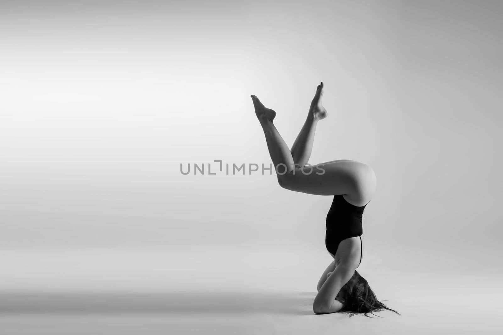 Portrait of a beautiful young woman wearing black sportswear working out in studio. Full length.