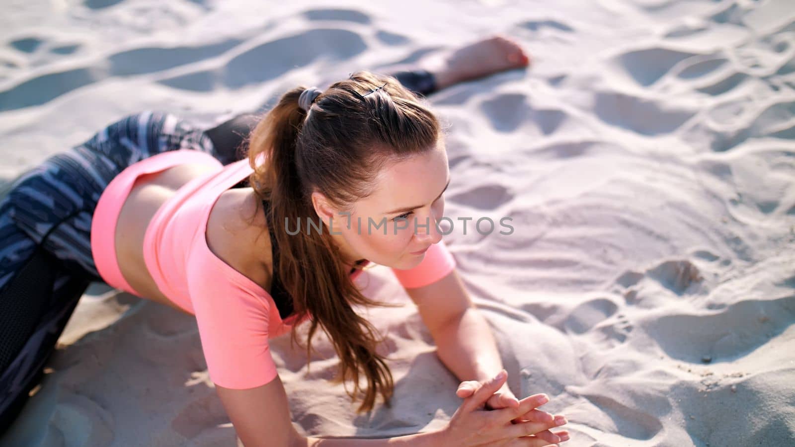 Healthy, young beautiful woman stretching, practicing yoga on the beach, at sunrise, Makes exercises for balance and coordination, deep muscle tone. relaxation of muscles, mind. High quality photo