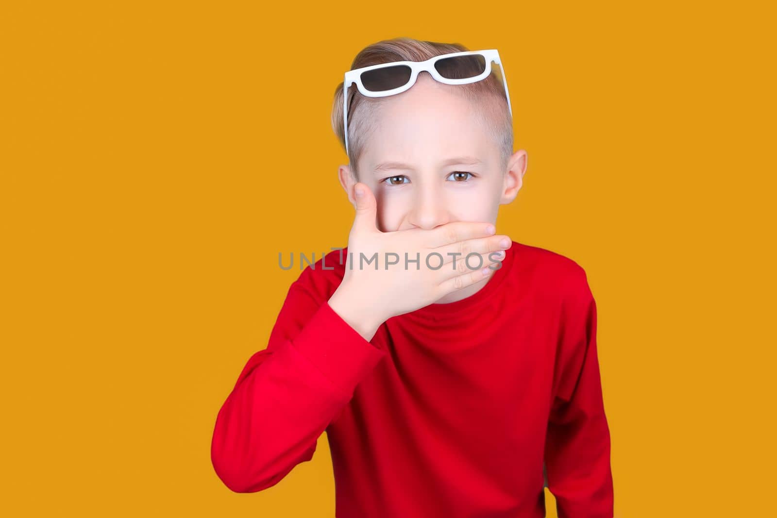 a child in children's 3D glasses covered his mouth with his hand