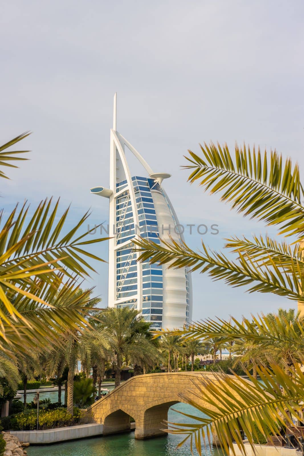 Burj al arab hotel in Dubai during the day and amid palm trees.