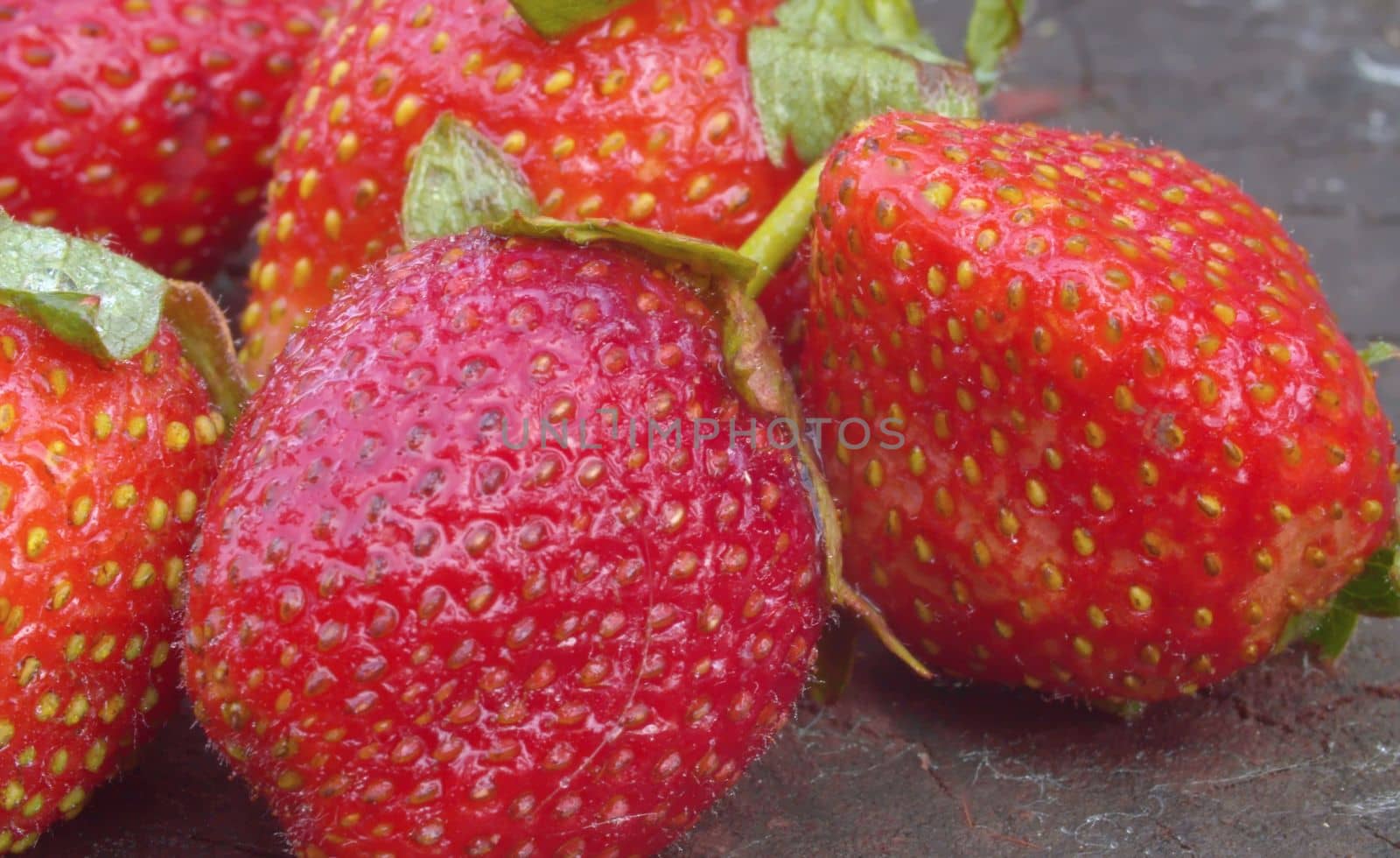 Ripe strawberries on a wooden board by Alize