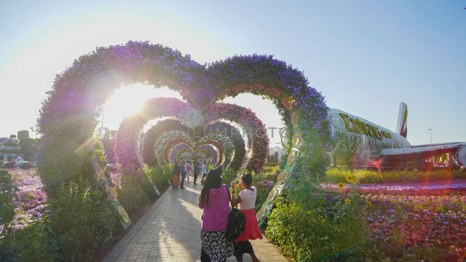 Heart shaped flower beds at the Alley of Hearts. Dubai Miracle Garden is famous for its extraordinary flower installations. A couple of people walking around at the park.