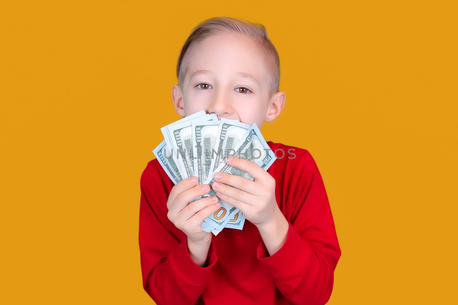 a child in red holds dollar bills