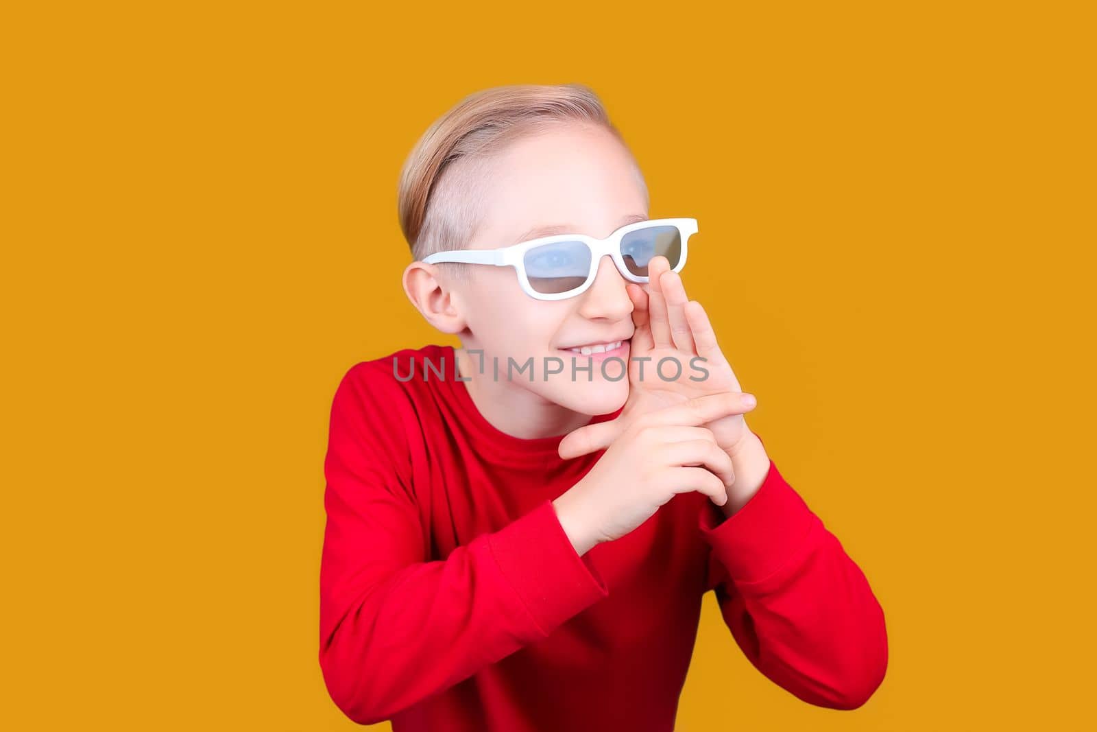 a child in 3D glasses puts his hand to his mouth and screams