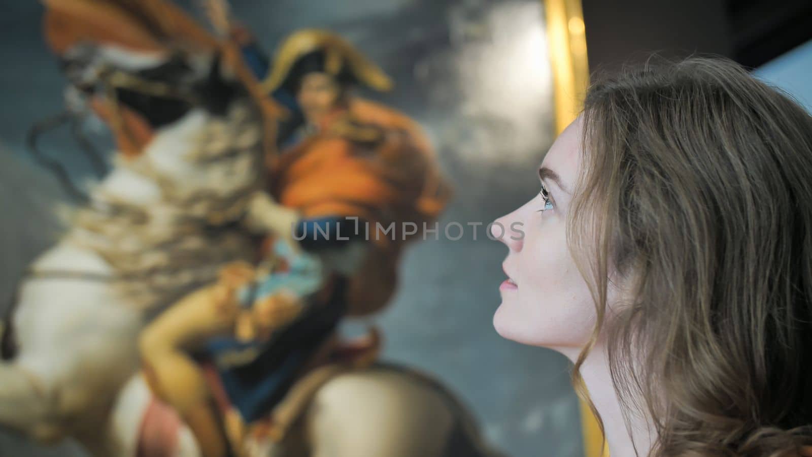 A girl examines a picture in a museum