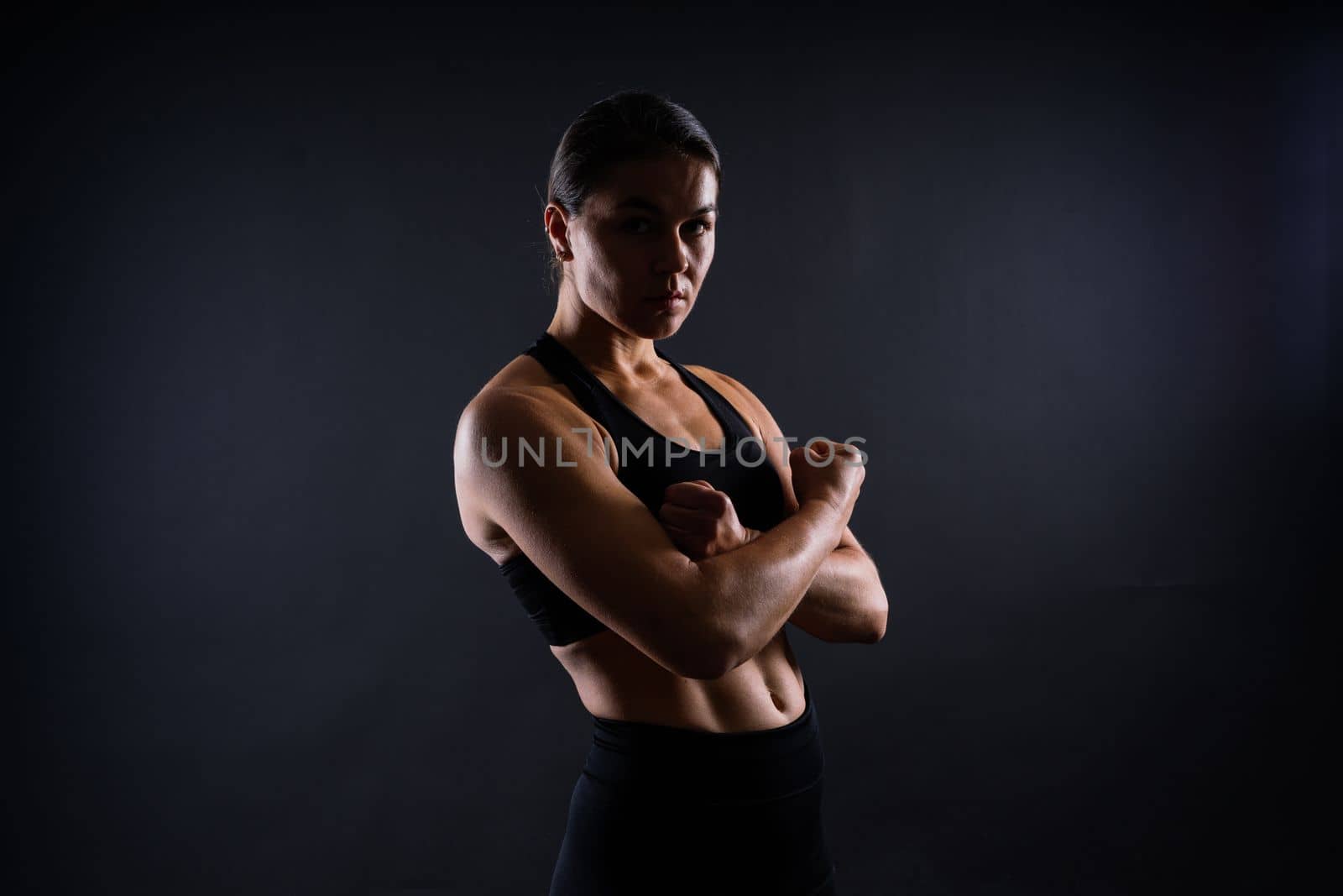 Strong sportswoman in boxing gloves prepared high kick. Isolated on a white, red, yellow background