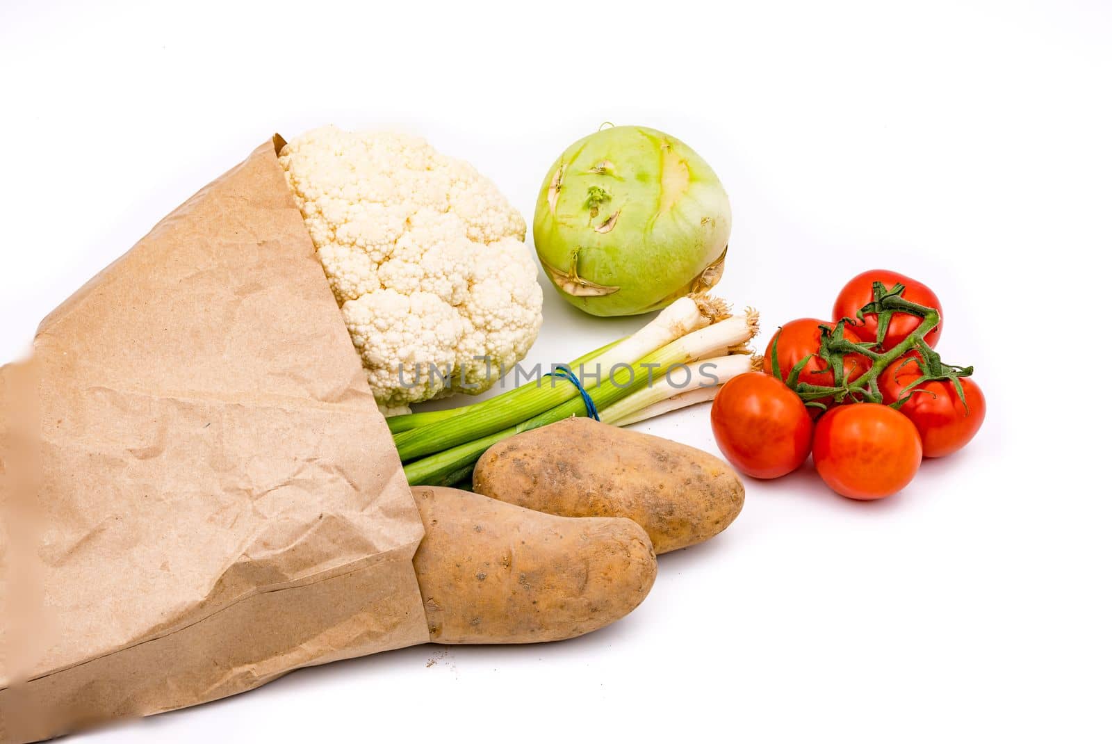 Fresh organic vegetables in a sustainable grocery bag isolated with focus stacking against a white background