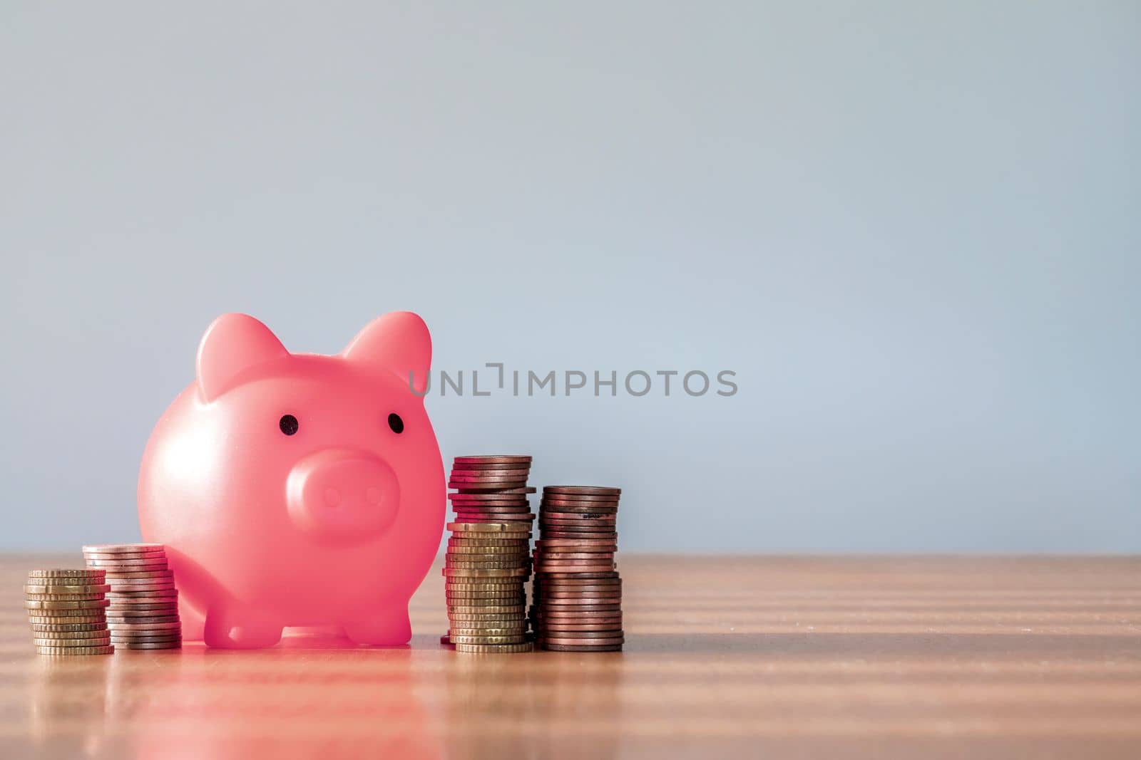 Piggy bank pink colour with money stack step up growing growth saving money, Concept financial business investment. Copy space for your text gray background close up