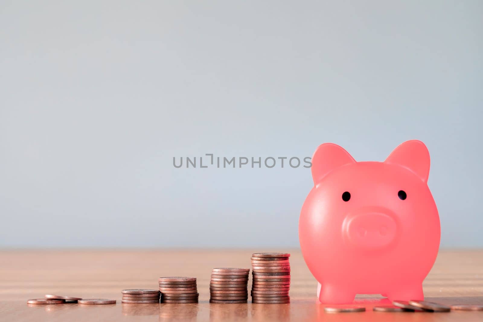 Piggy bank pink colour with money stack step up growing growth saving money, Concept financial business investment. Copy space for your text gray background close up