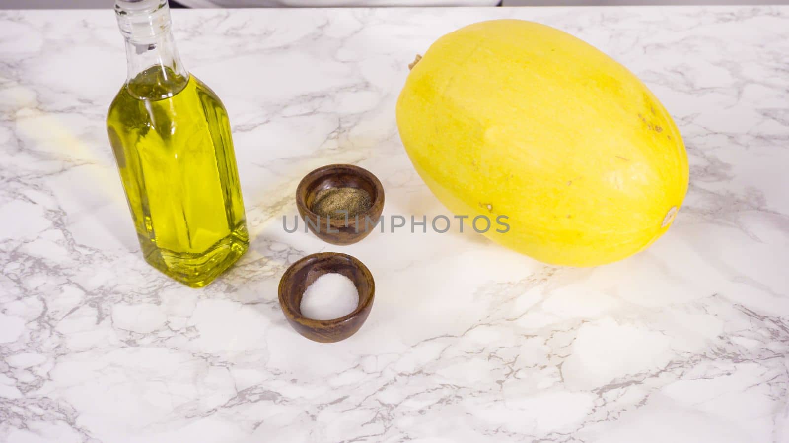 Step by step. Preparing organic spaghetti squash with olive oil, salt, and pepper.