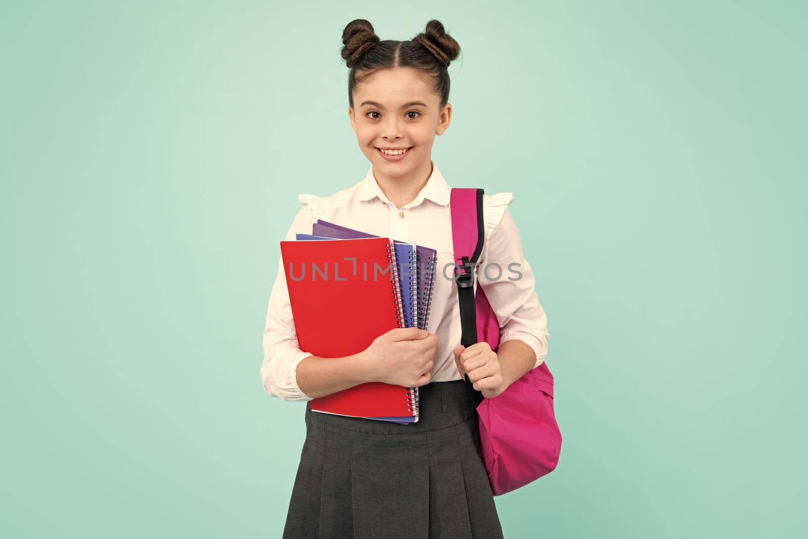 Schoolchild, teenage student girl hold book on blue isolated studio background. School and education concept. Back to school. Happy teenager, positive and smiling emotions of teen girl. by RedFoxStudio