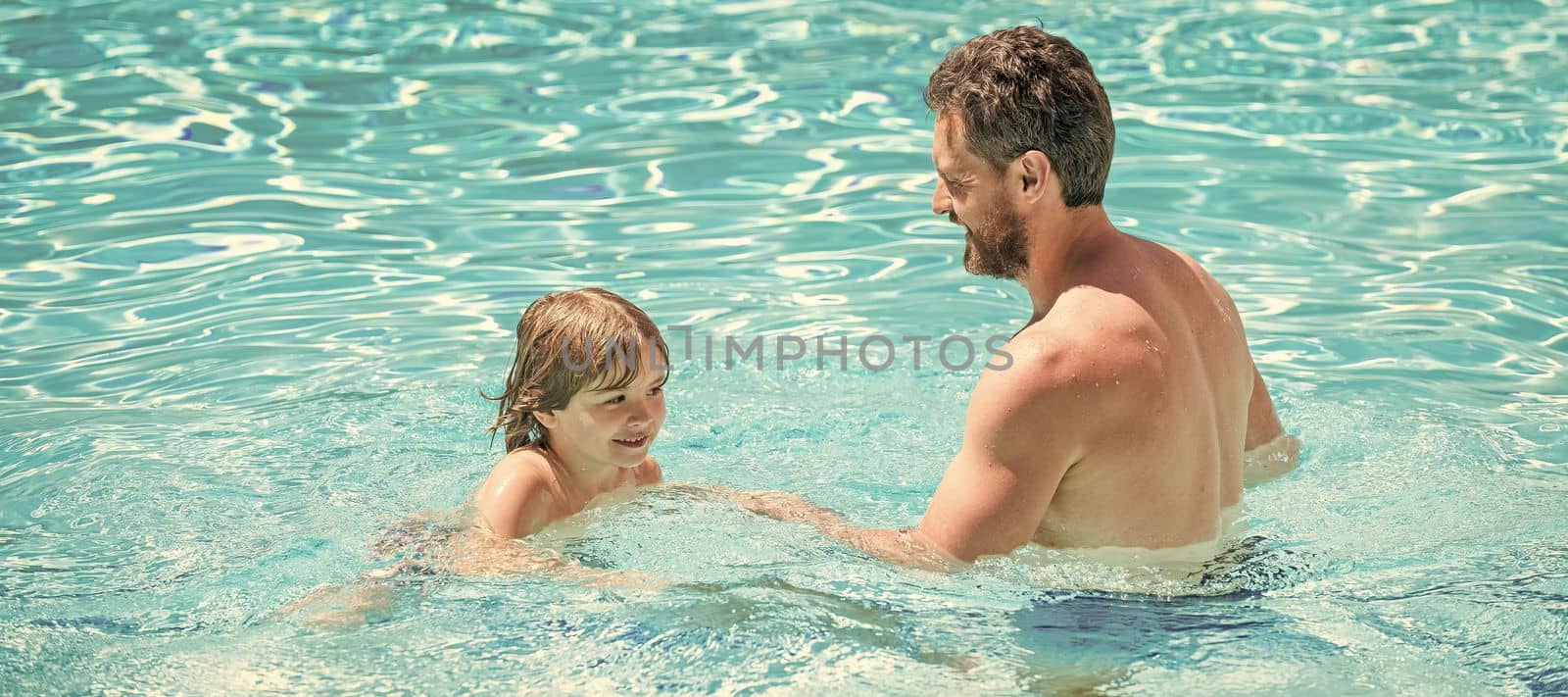 Father and son in swimming pool, banner with copy space. happy family of father and son boy having fun in summer swimming pool, family.