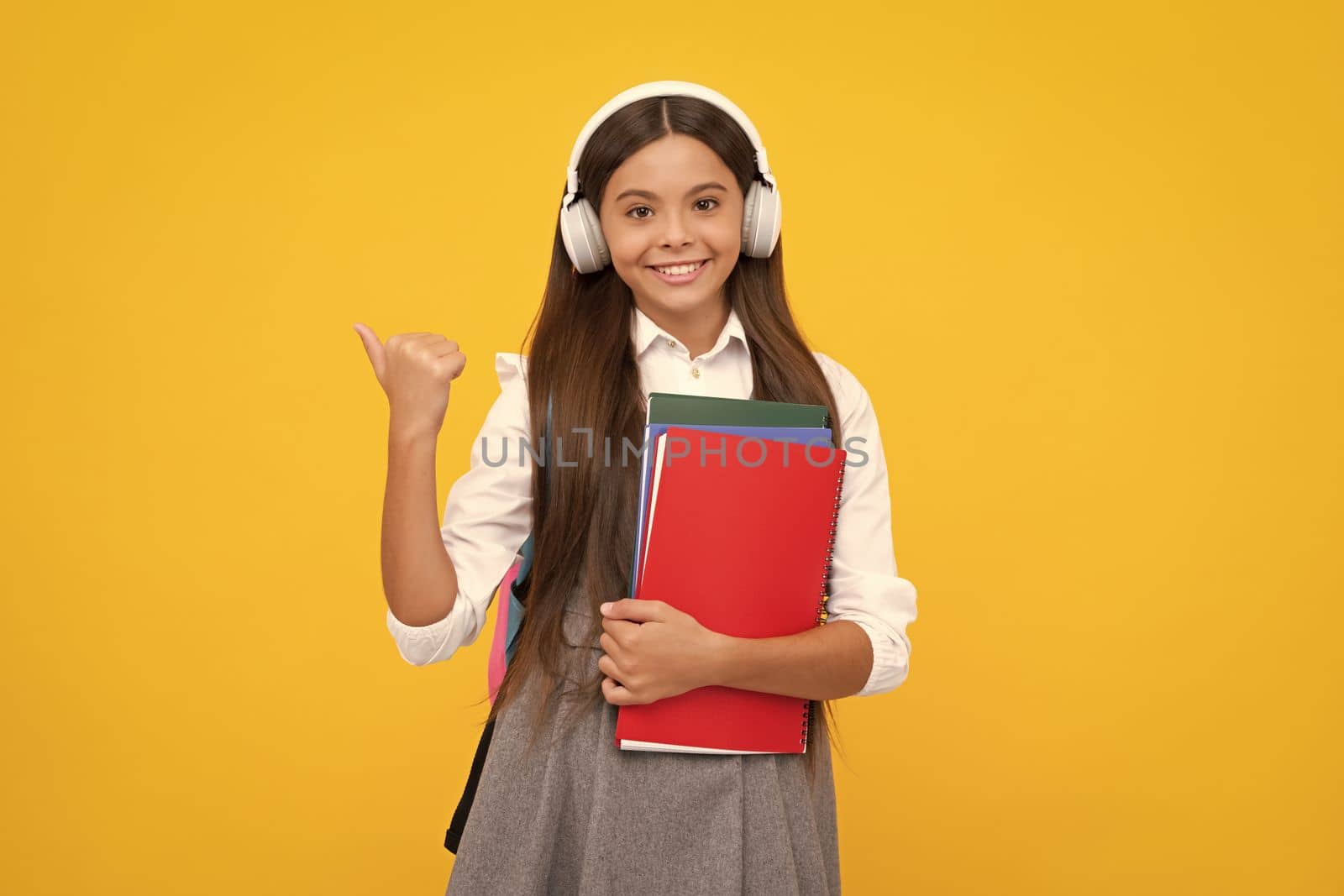 School child girl with headphones and book. Happy girl face, positive and smiling emotions