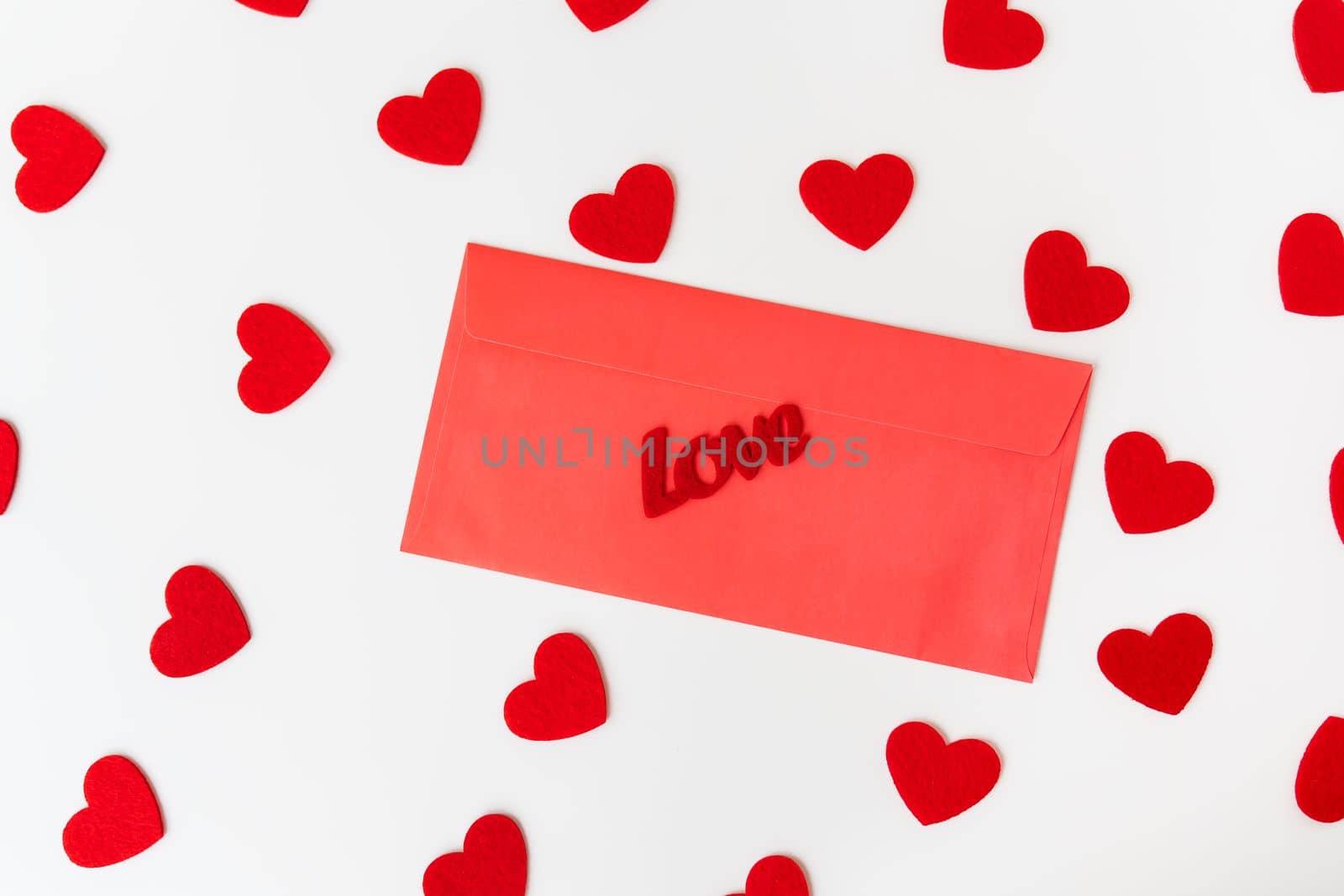 A love letter, the inscription of love on a red paper envelope on the background of small red hearts. The concept of St. Valentine's Day. by sfinks