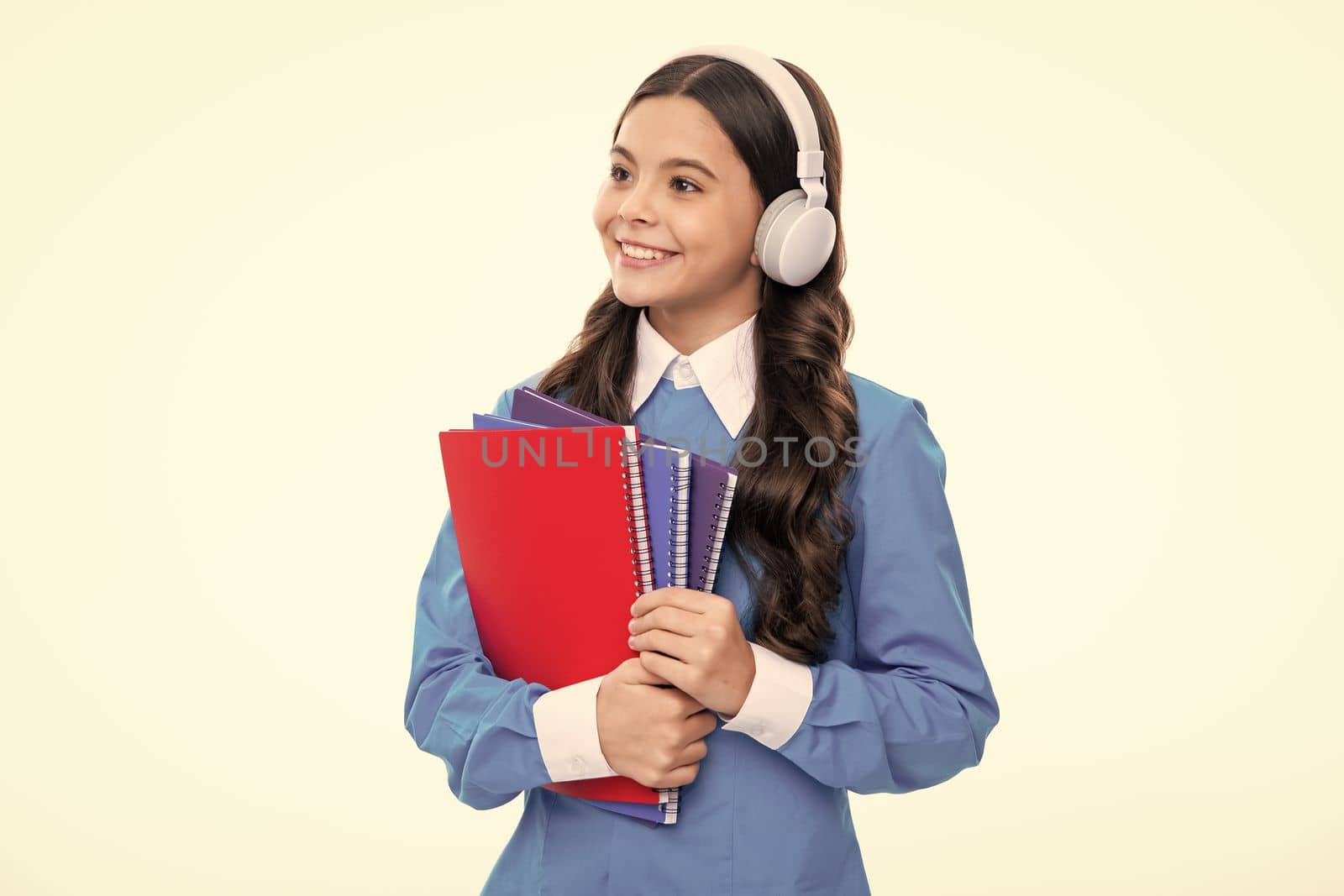 School teen girl in headphones and books, copy space, back to school