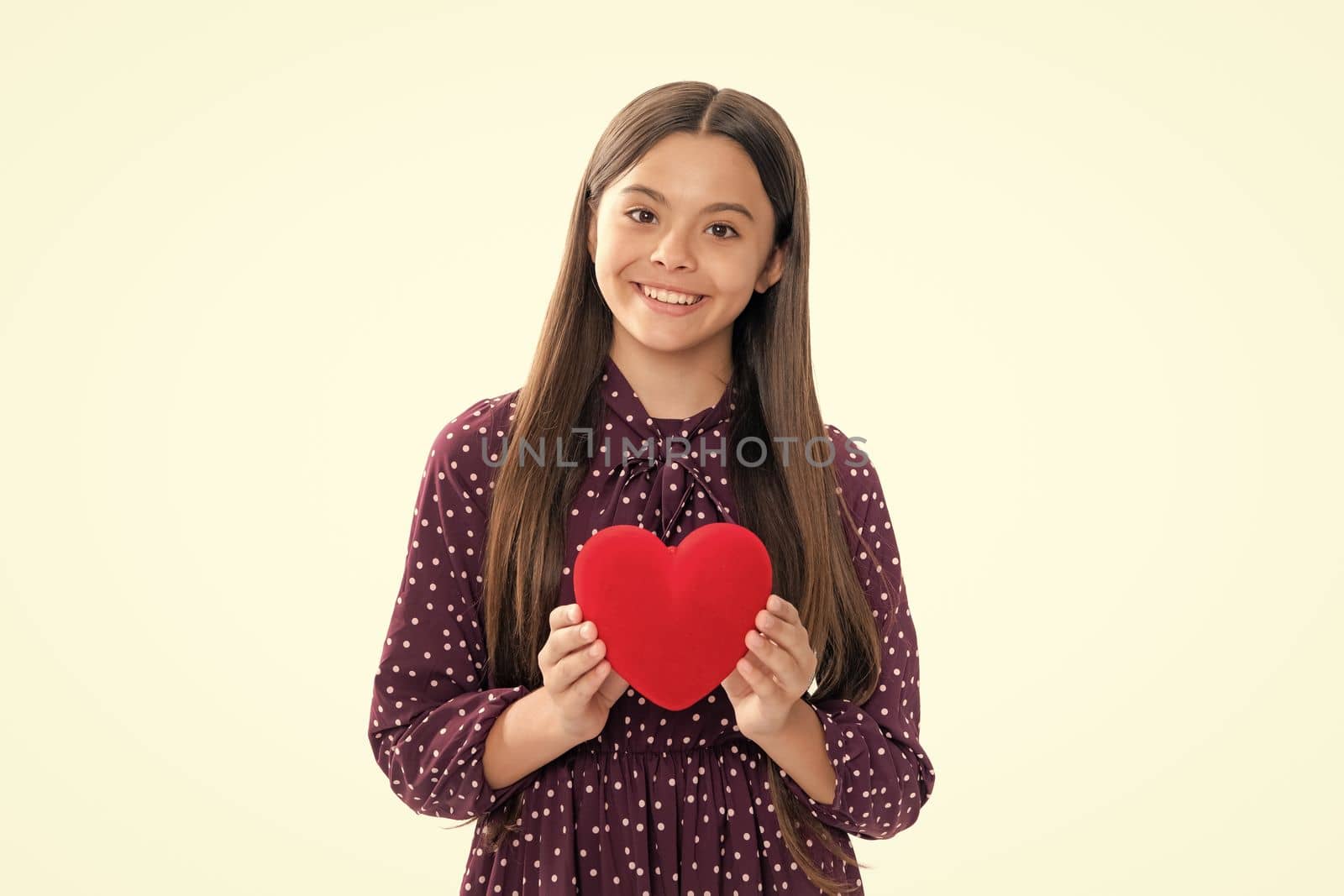 Valentines Day. Dreaming cute teen child with red heart. Portrait of happy smiling teenage child girl