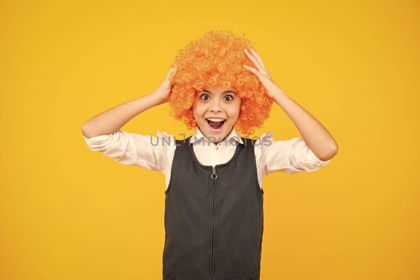 Funny kid in curly redhead wig. Time to have fun. Teen girl with orange hair, being a clown. Excited face, cheerful emotions of teenager girl. by RedFoxStudio