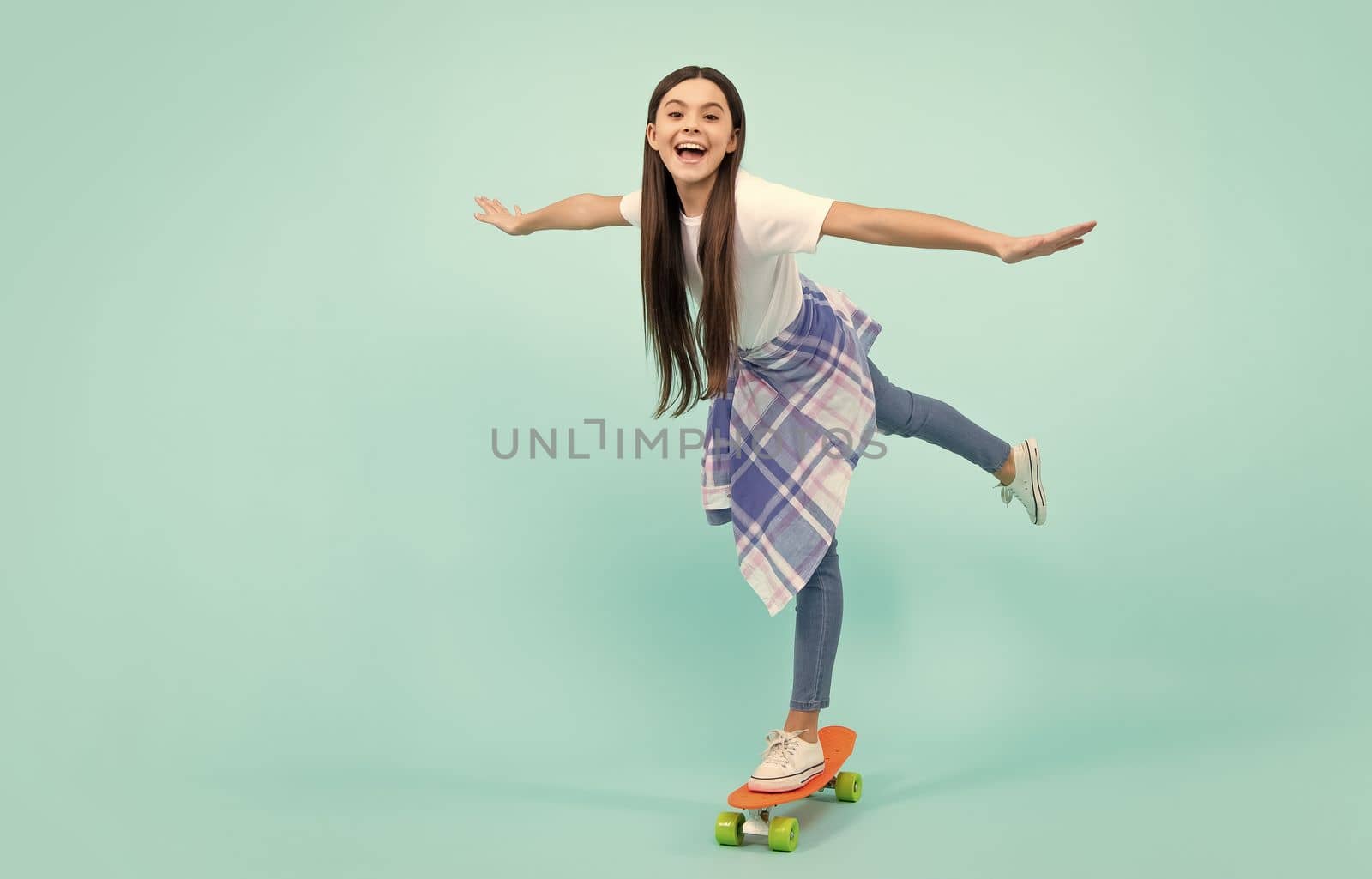 Teen hipster girl skater with skateboard on isolated background. Summer kids trend, urban teenage style. Jump and run. Happy teenager, positive and smiling emotions of teen girl. by RedFoxStudio
