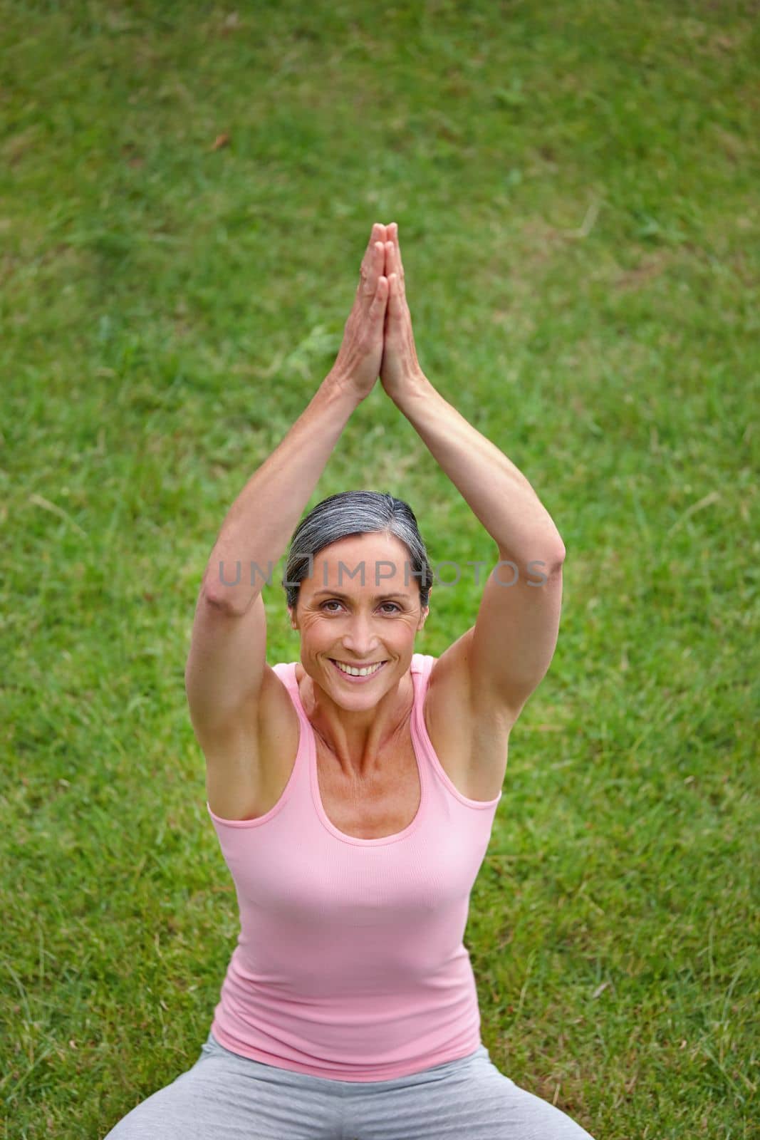 Yoga calms her. Portrait of an attractive mature woman doing yoga outdoors. by YuriArcurs