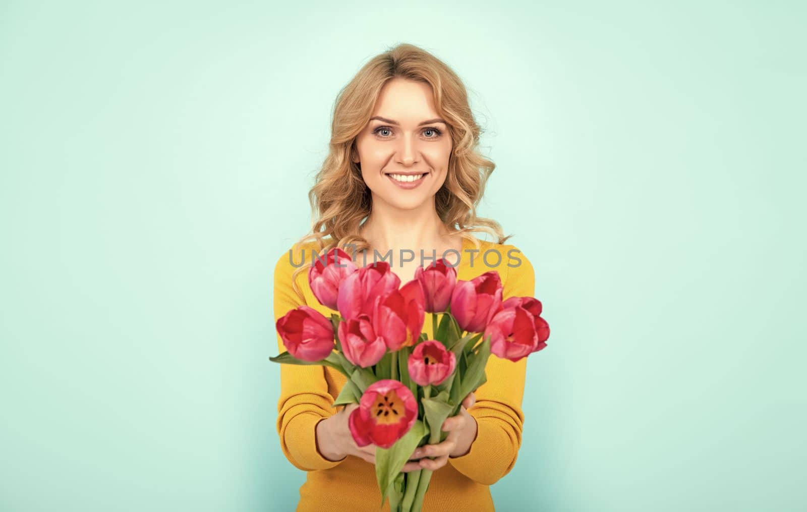 cheerful girl with spring tulip flowers on blue background.