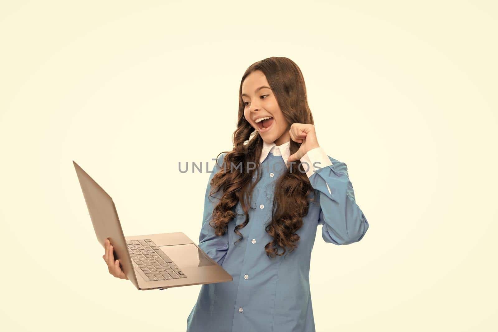 amazed kid portrait has long curly hair work online on laptop isolated on white, school blog.
