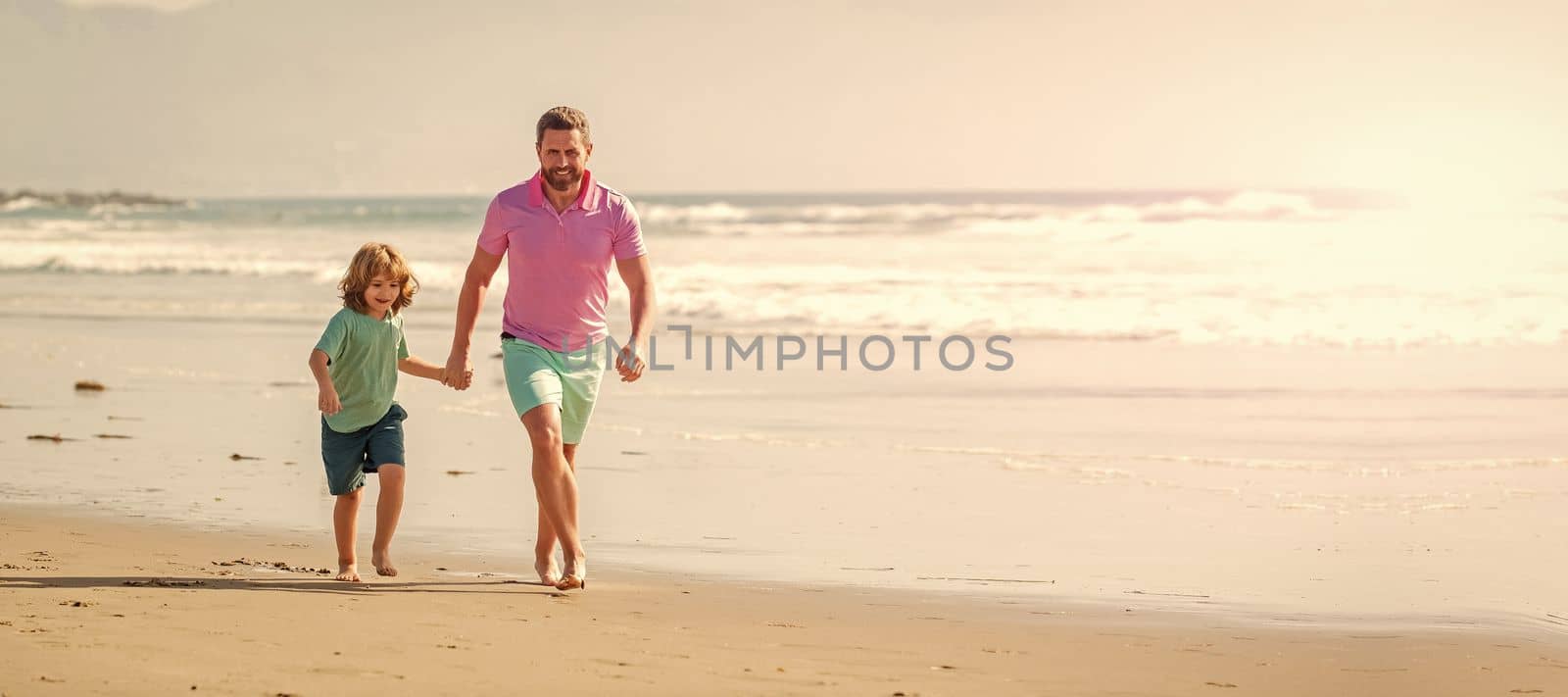 Banner of father and son run on summer sea beach. happy father and son run on summer beach, activity.