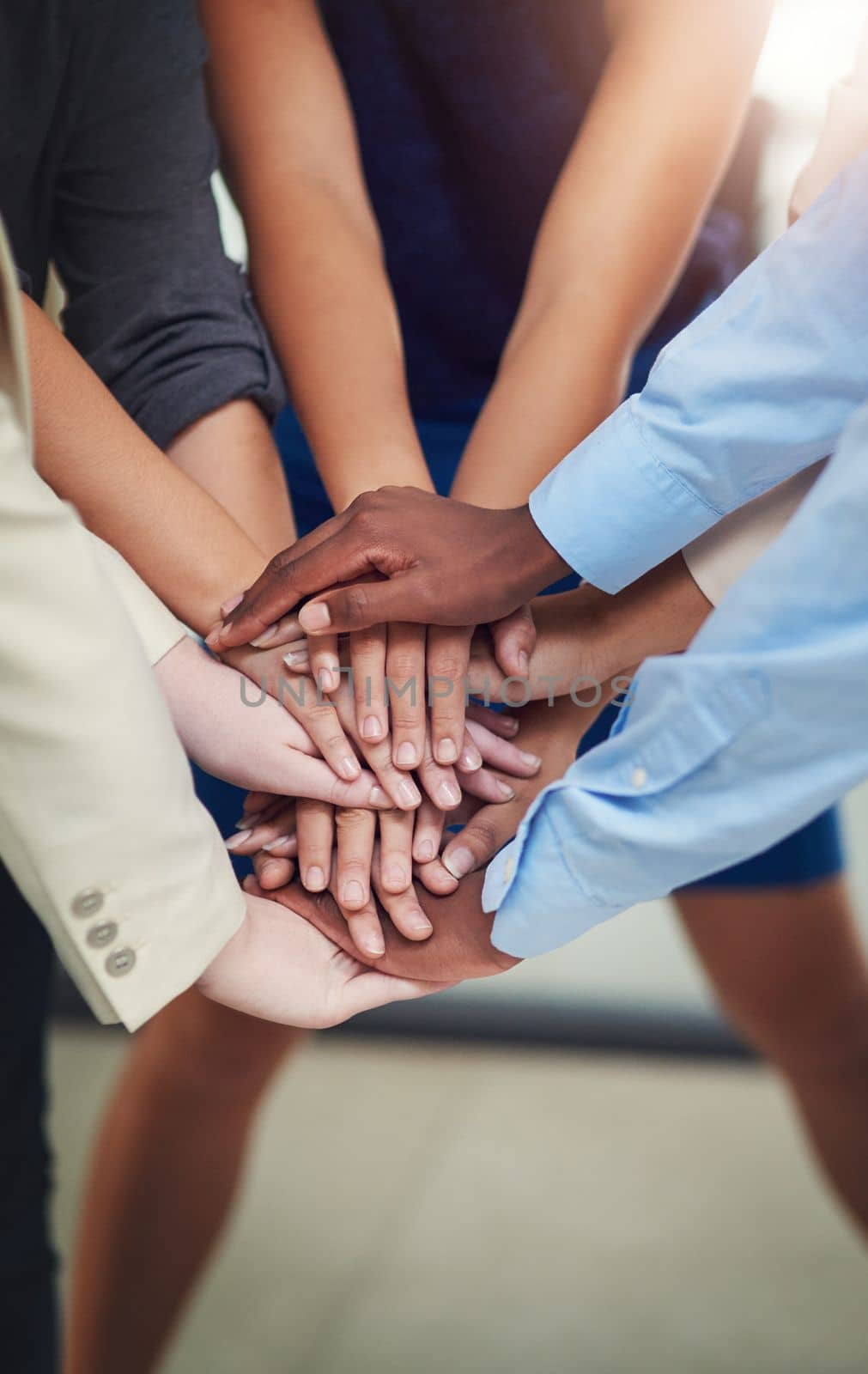 Let your hands do the talking. High angle shot of a group of unrecognizable businesspeople standing with their hands in a huddle. by YuriArcurs