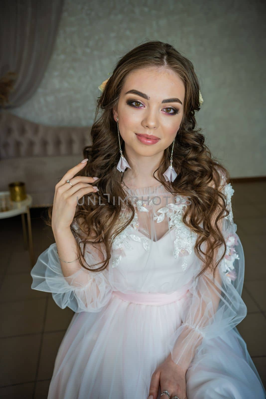 Beautiful festive make-up on a girl in a white dress