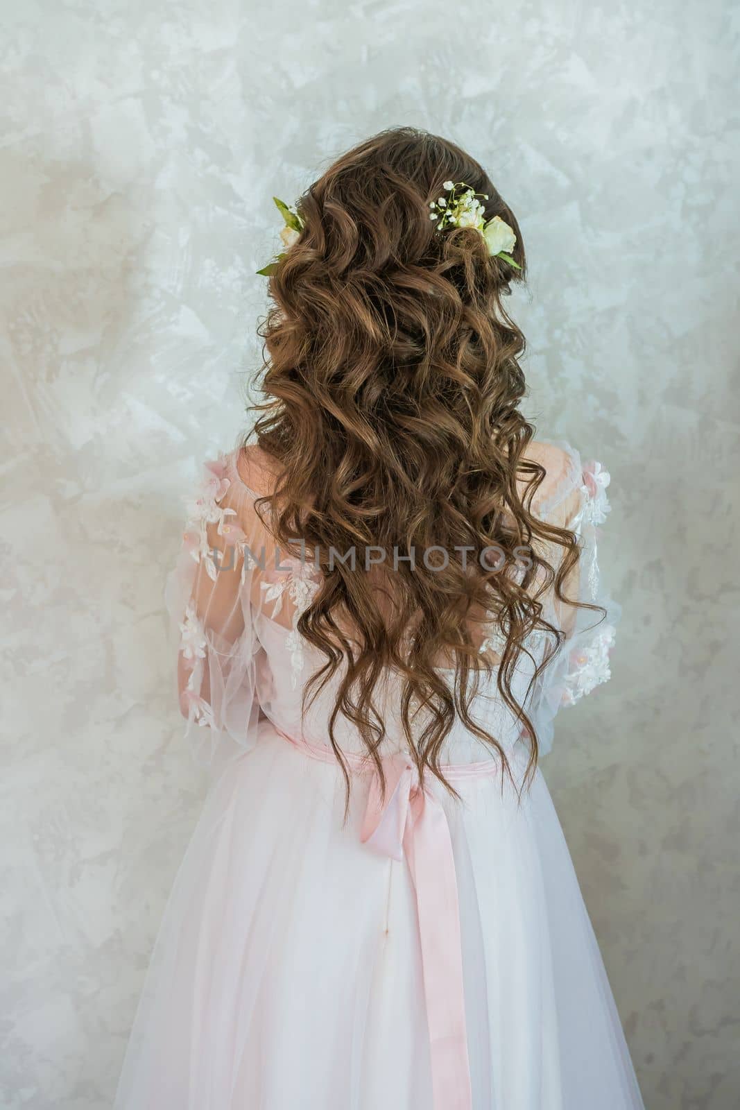 A girl with spinners demonstrates a wedding hairstyle