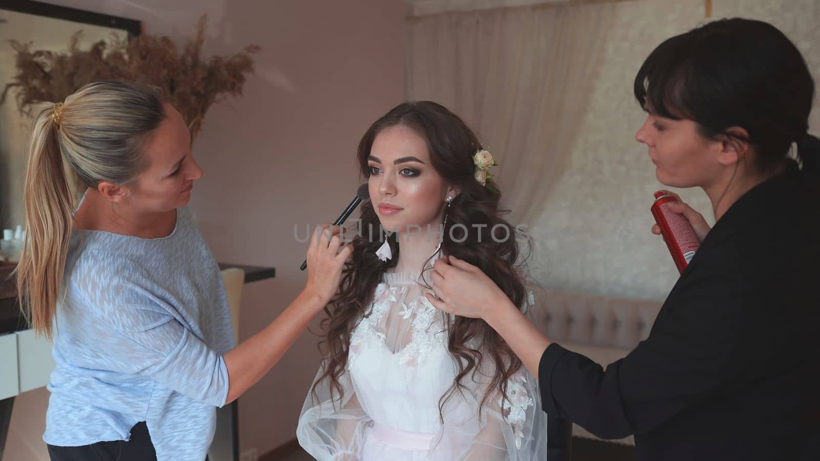 Makeup artist and hairdresser work on the image of the model