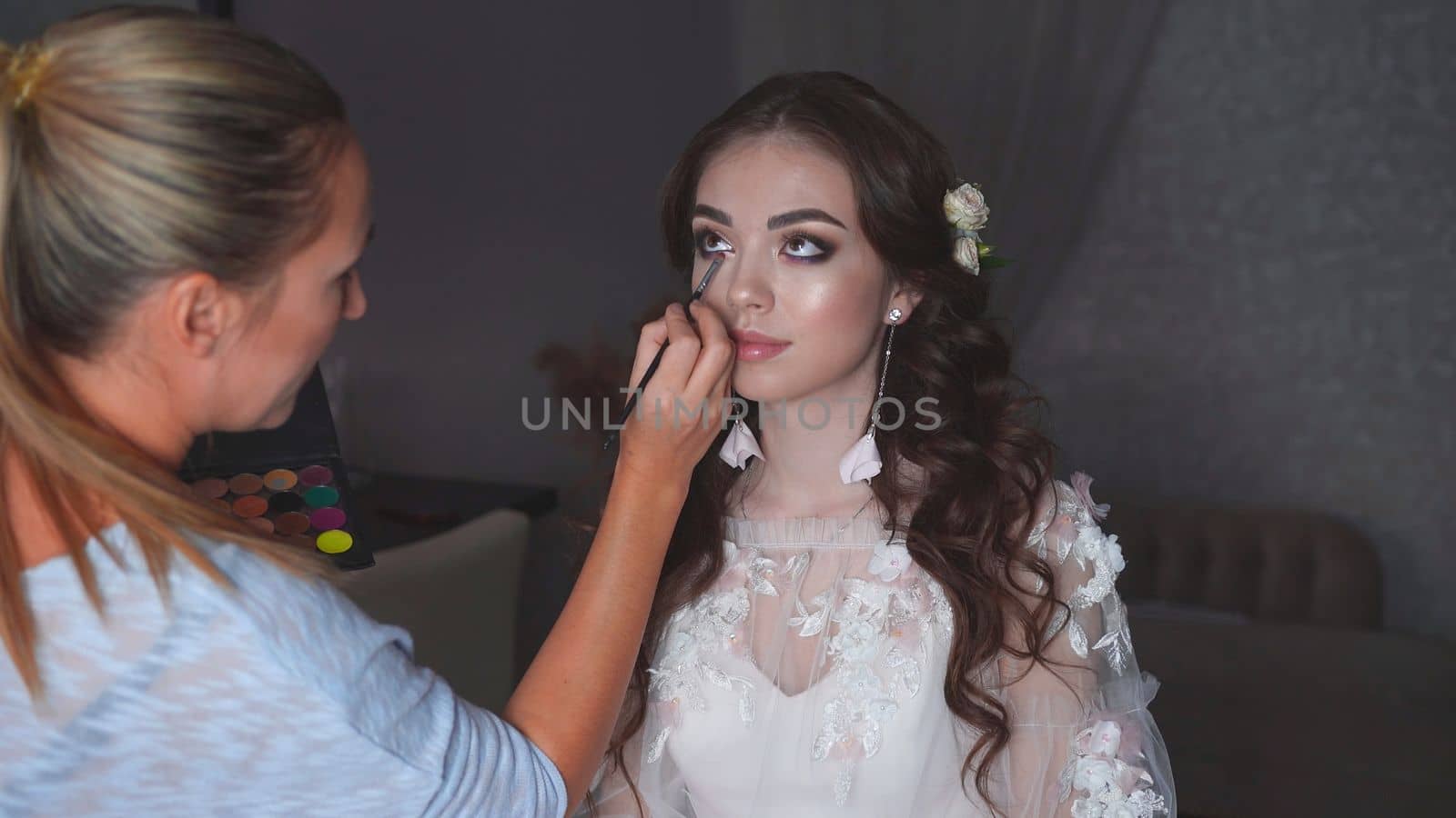 Makeup artist paints an eye for the bride on her wedding day