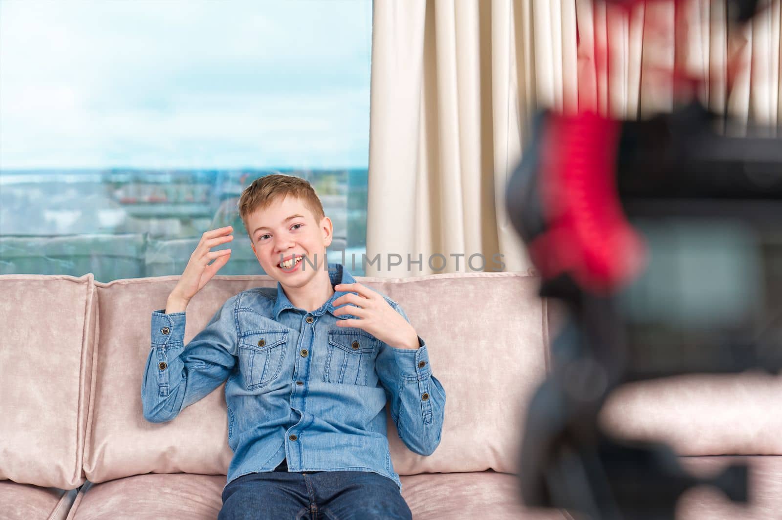 beautiful happy boy teenager making video blog for social networks in living room influencer vlogger. making vlog for social media concept, video blogger or influencer making video