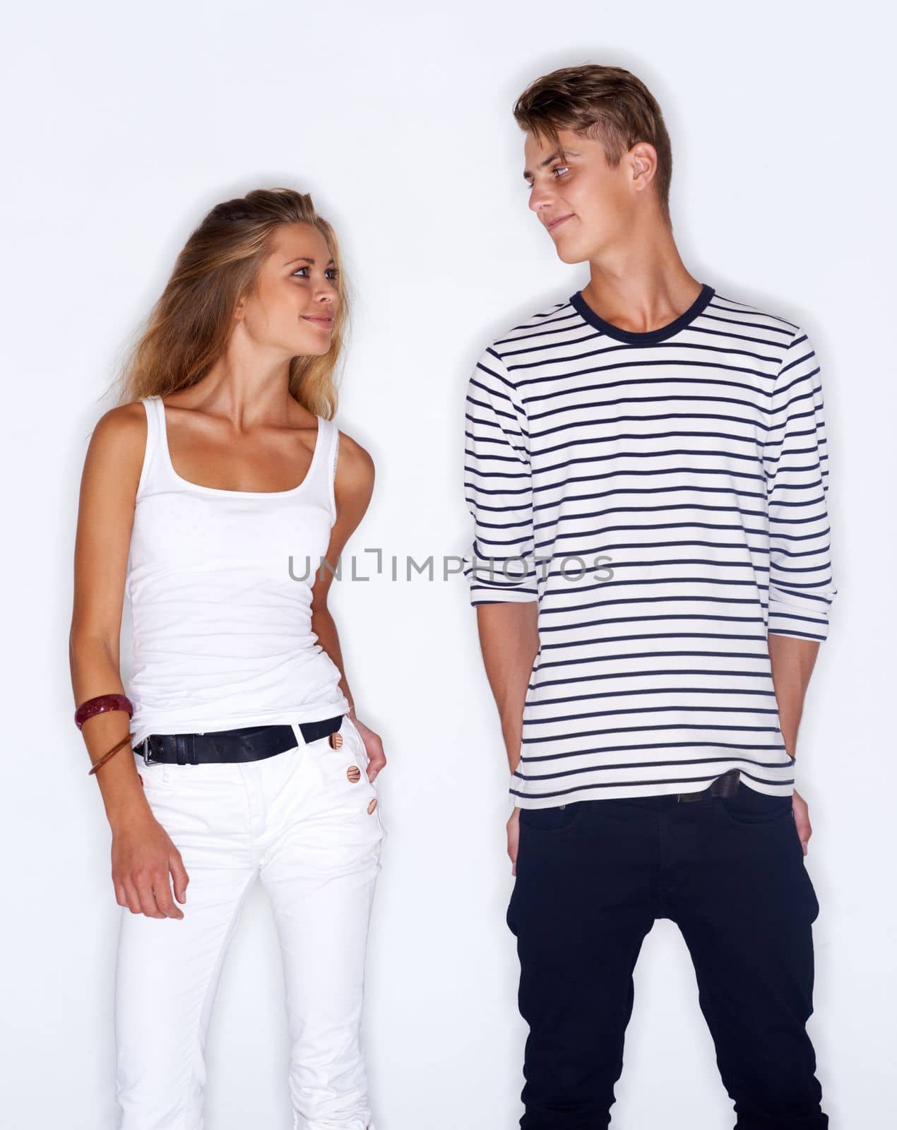 Fashion fever. Young trendy couple standing together on white background