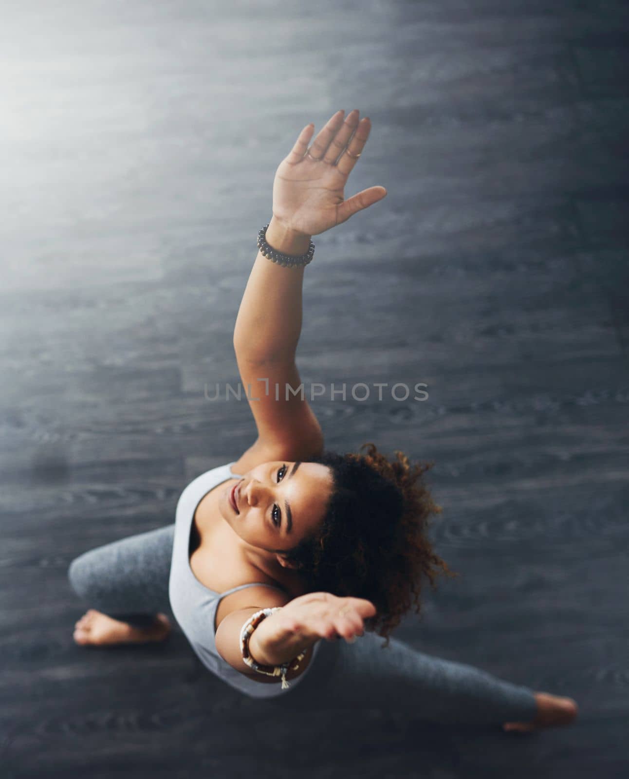 Yoga is exercise for both body and soul. High angle shot of a young woman practising yoga. by YuriArcurs