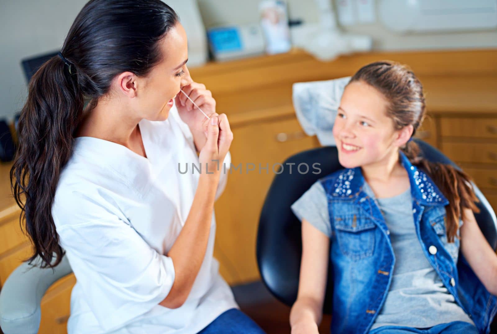 Your teeth look very healthy. a female dentist and child in a dentist office