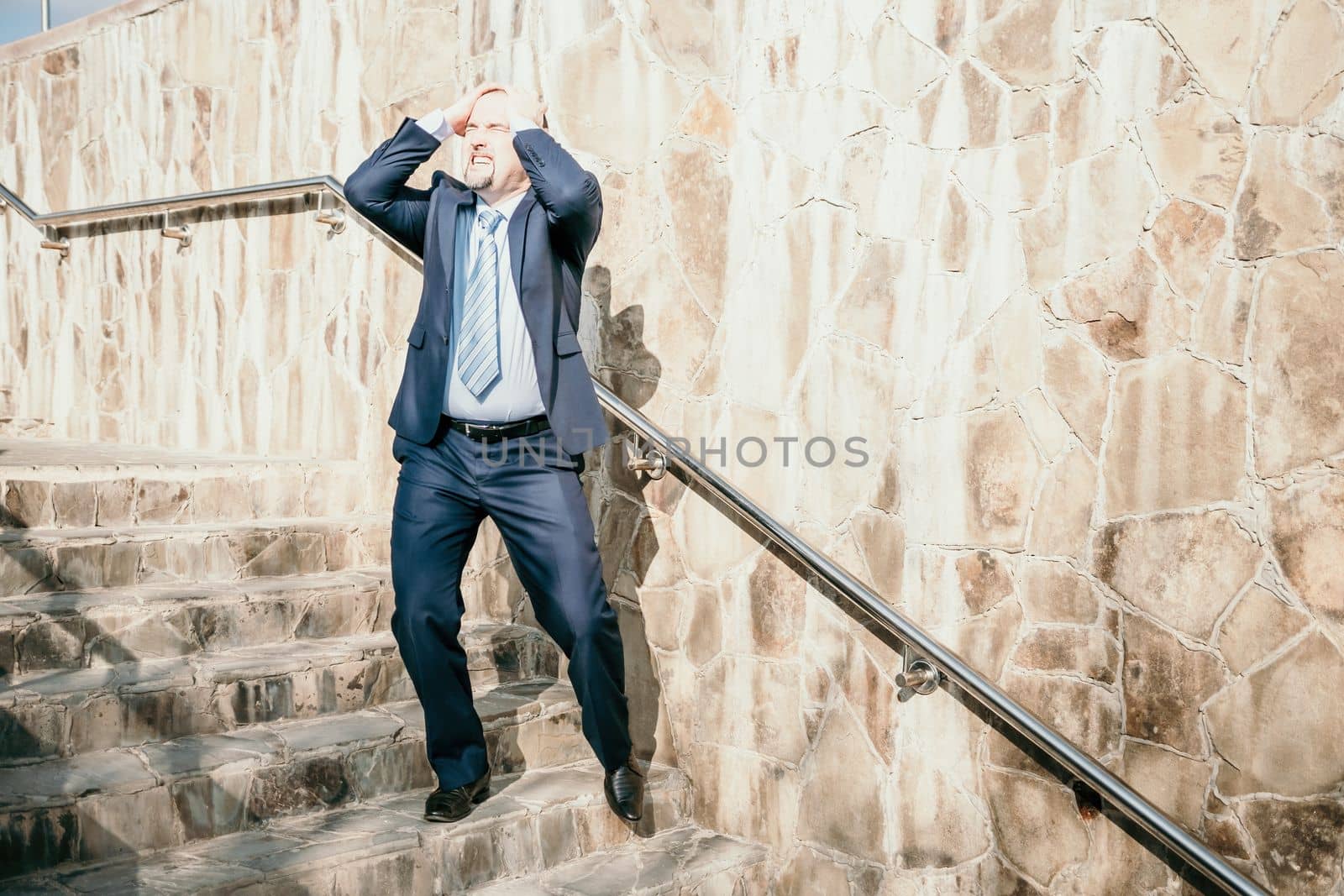 Portrait of a senior professional man in a suit with various problems. A middle-aged businessman with a briefcase descends the stairs.