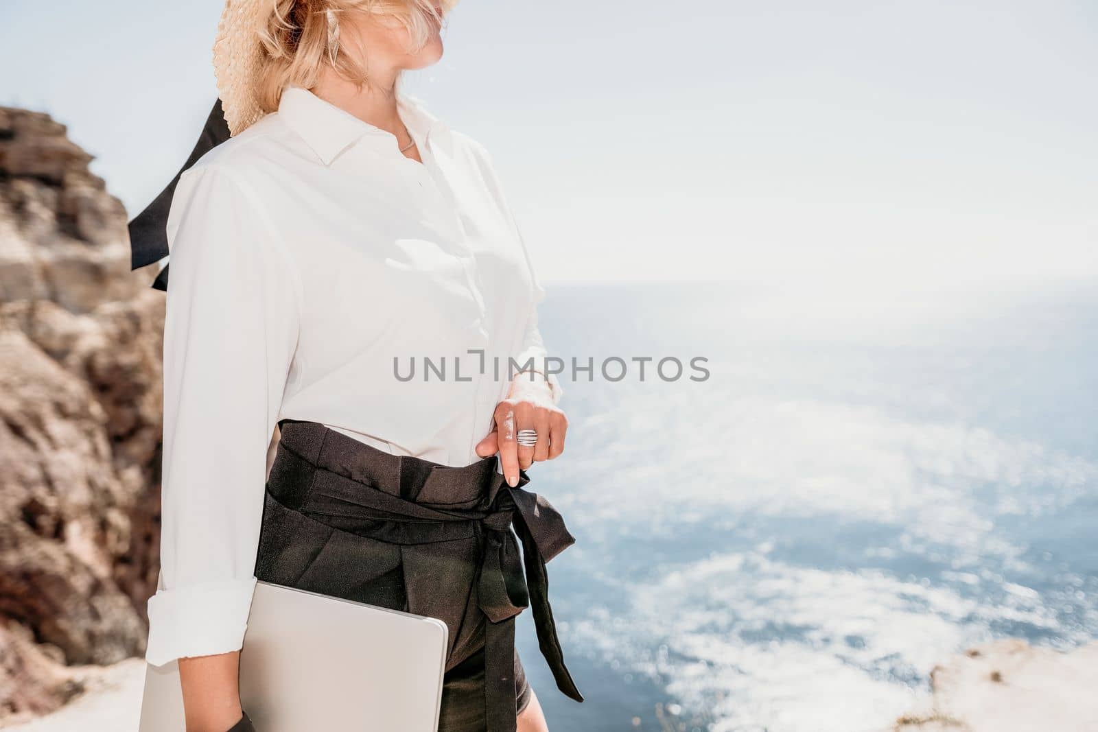 Happy girl doing yoga with laptop working at the beach. beautiful and calm business woman sitting with a laptop in a summer cafe in the lotus position meditating and relaxing. freelance girl remote work beach paradise
