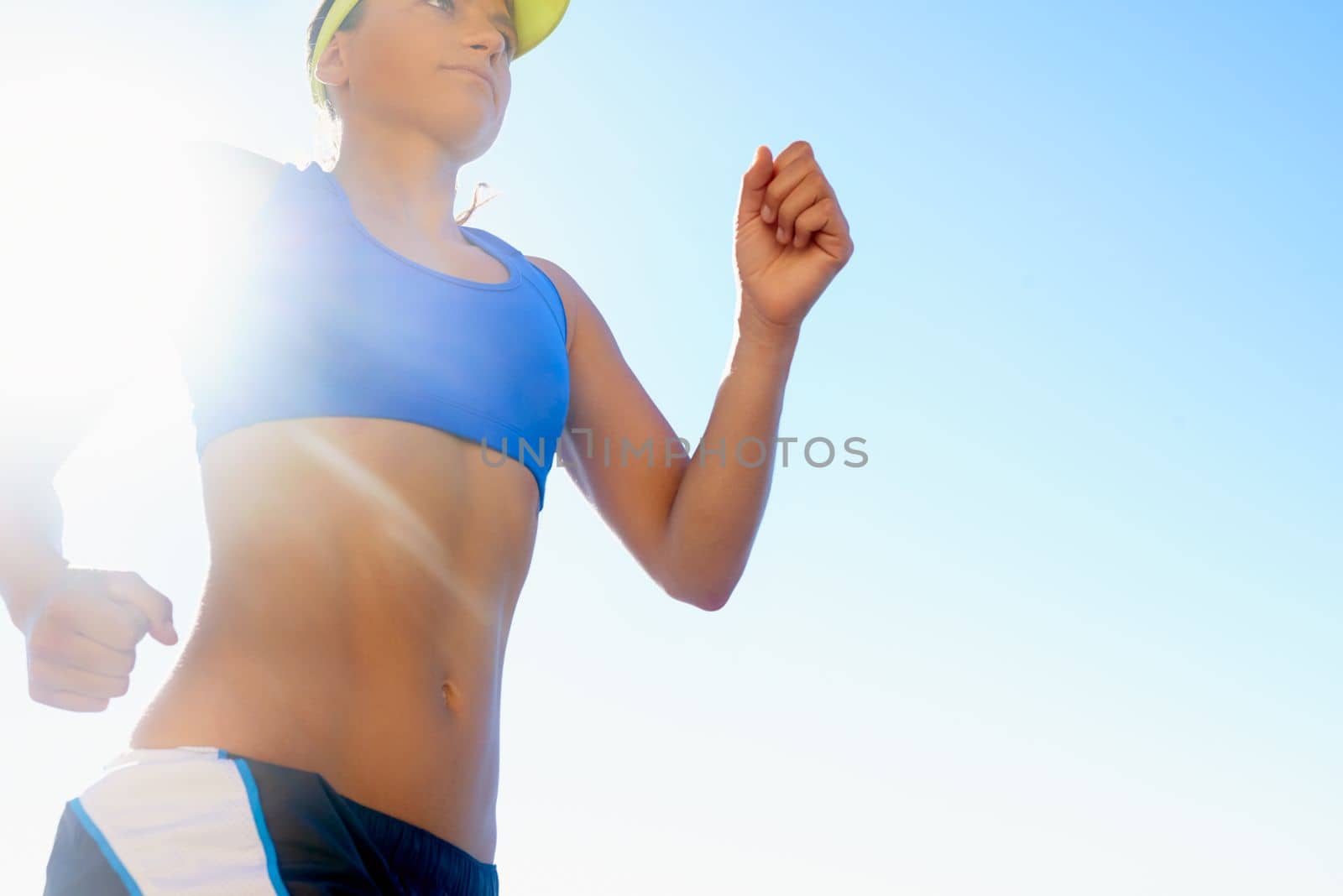 Running with determination. A beautiful young woman running outside. by YuriArcurs