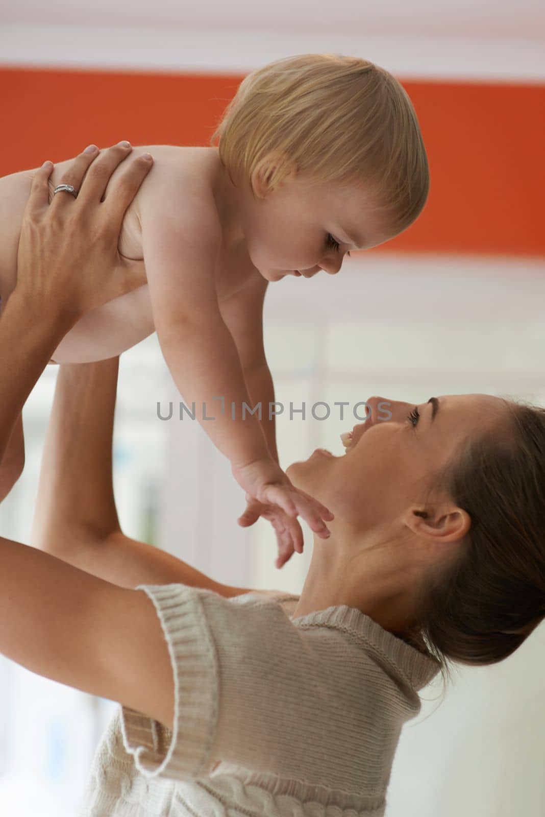 Her love for him is unending. A mother lifting her baby boy up in the air