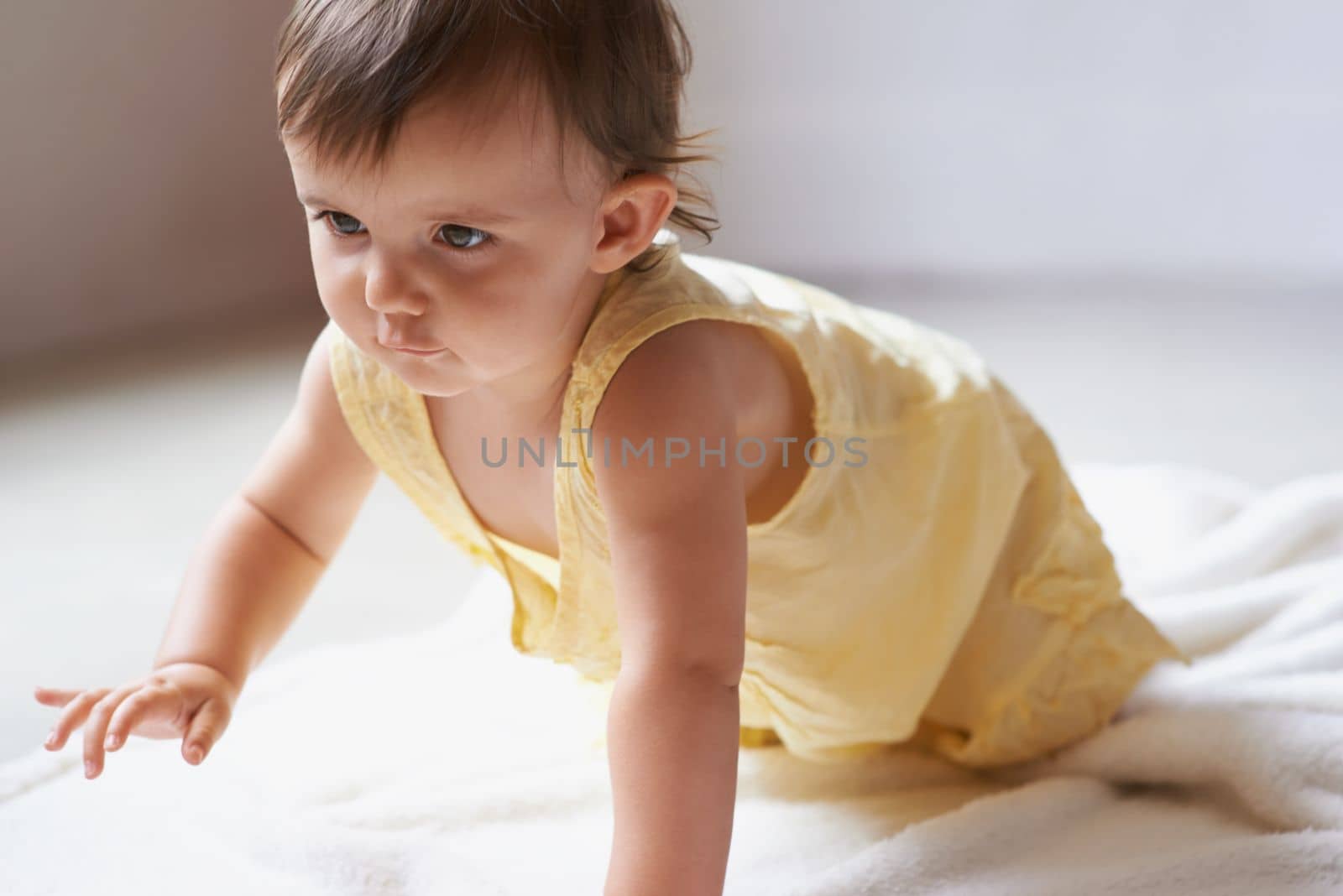 Tentative crawl...an adorable baby girl crawling on the floor. by YuriArcurs