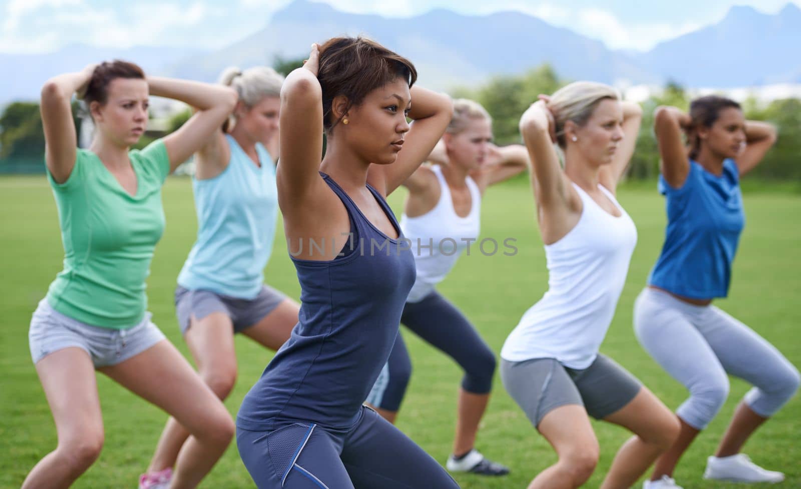 Sunshine and exercise. a group of young women exercising outdoors