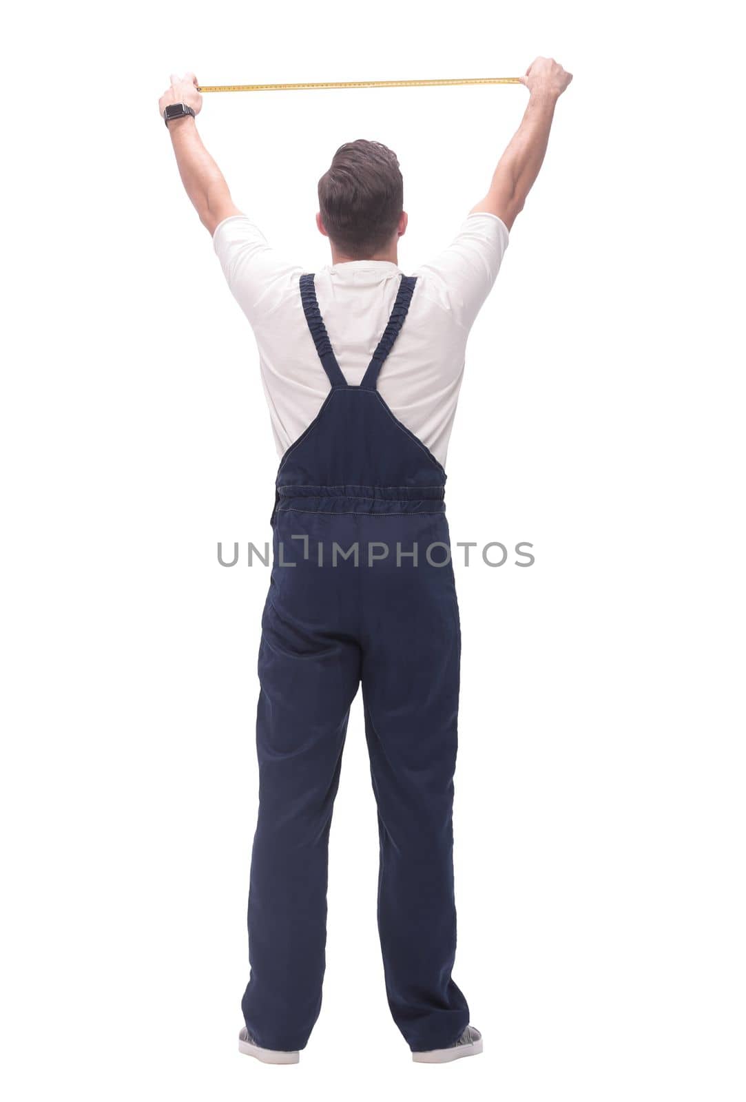 rear view. a man measuring something with a construction tape measure. isolated on white background
