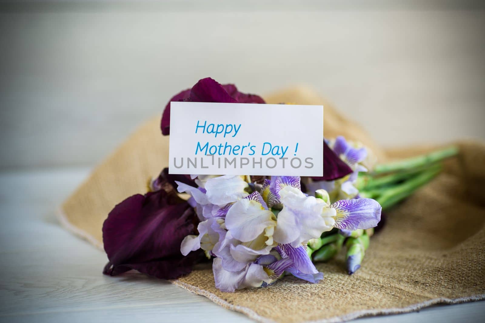 bouquet of beautiful blooming iris flowers on a light wooden background