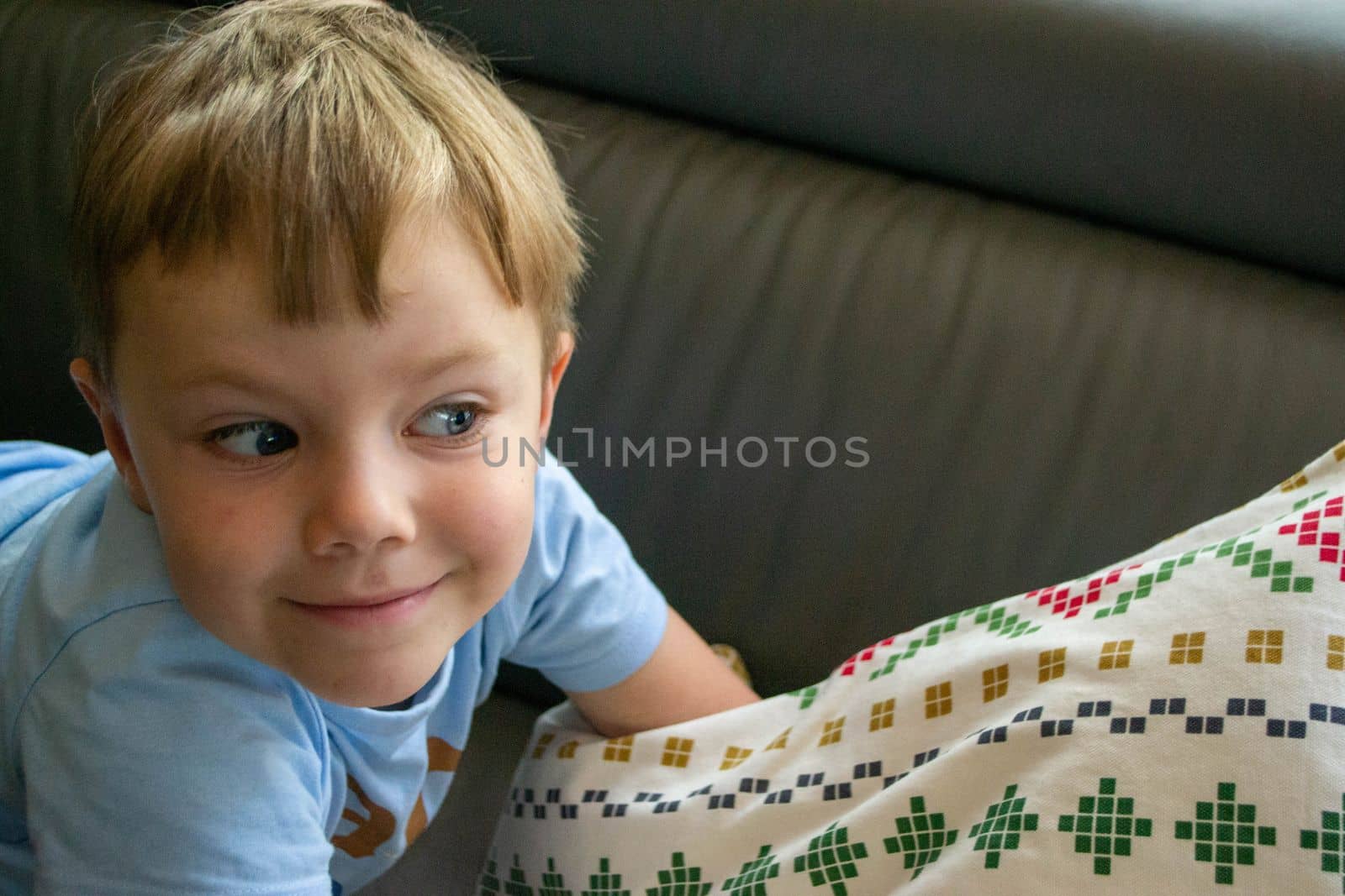 Close-up Of The Face Of A Beautiful 5 Year Old Boy Lying On The Bed. High quality photo