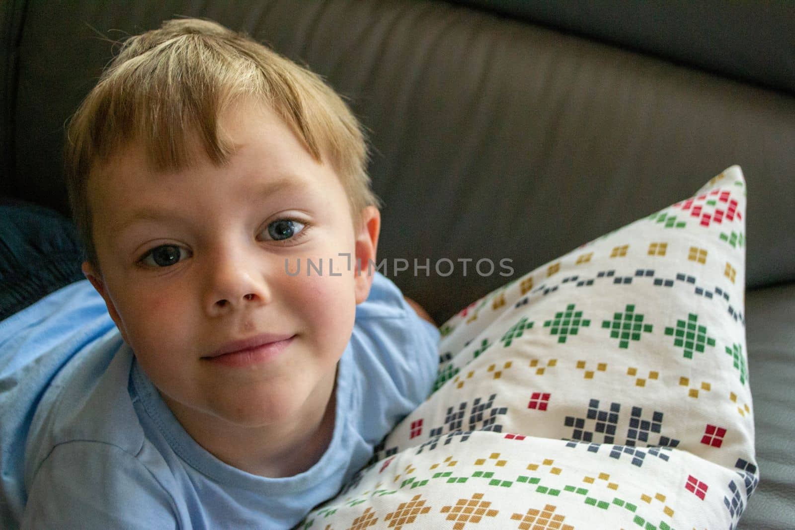 Close-up Of The Face Of A Beautiful 5 Year Old Boy Lying On The Bed. High quality photo