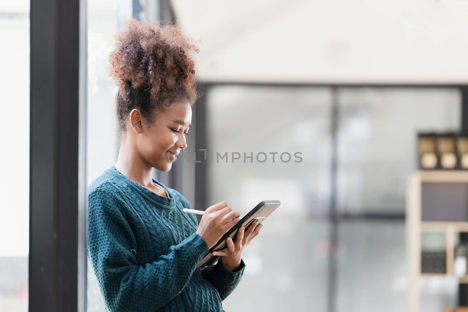 Beautiful young woman working using tablet at home.