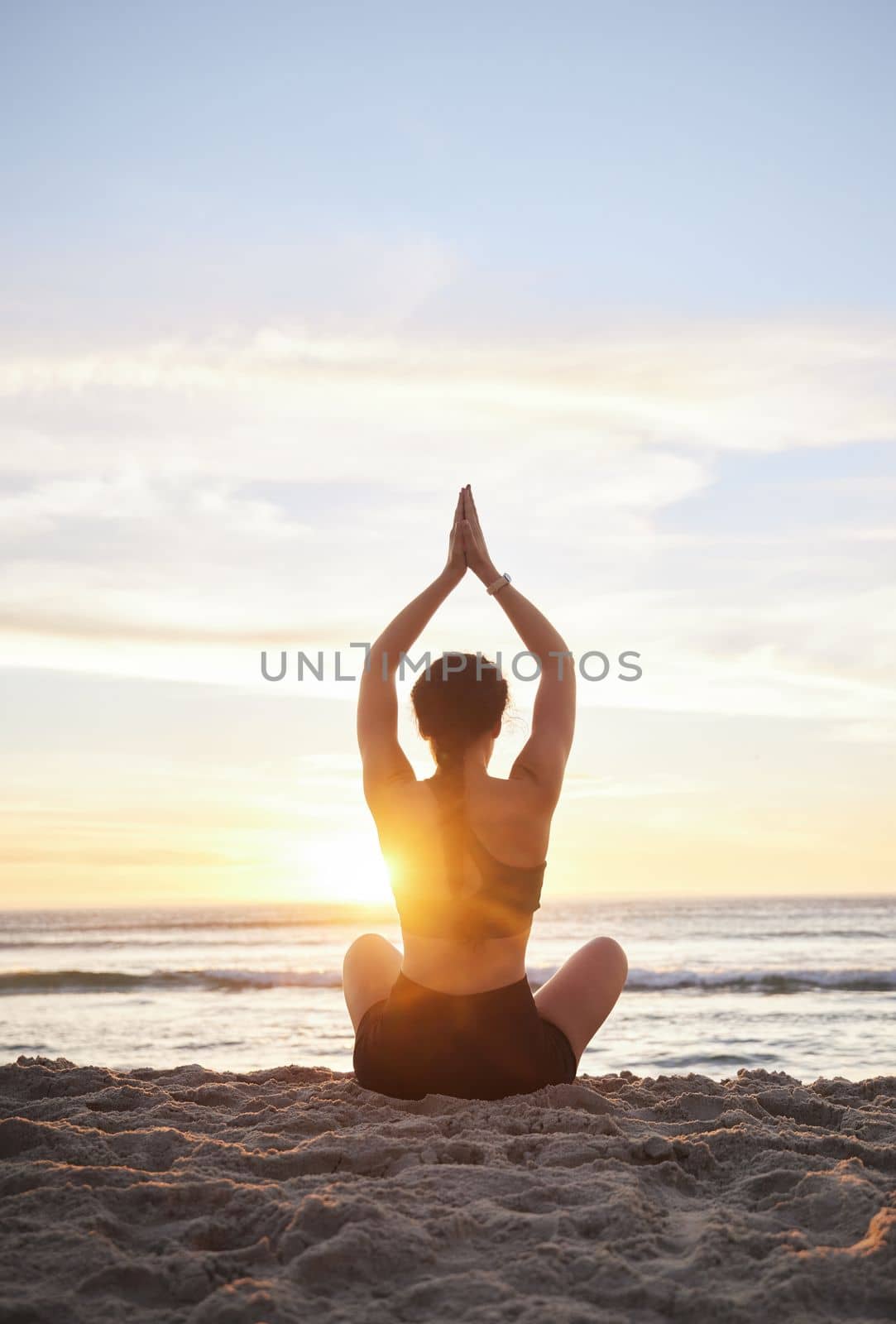 Woman, yoga and meditation on the beach for spiritual wellness or zen workout during sunset. Female yogi relaxing and meditating in sunrise for calm, peaceful mind or awareness by the ocean coast by YuriArcurs