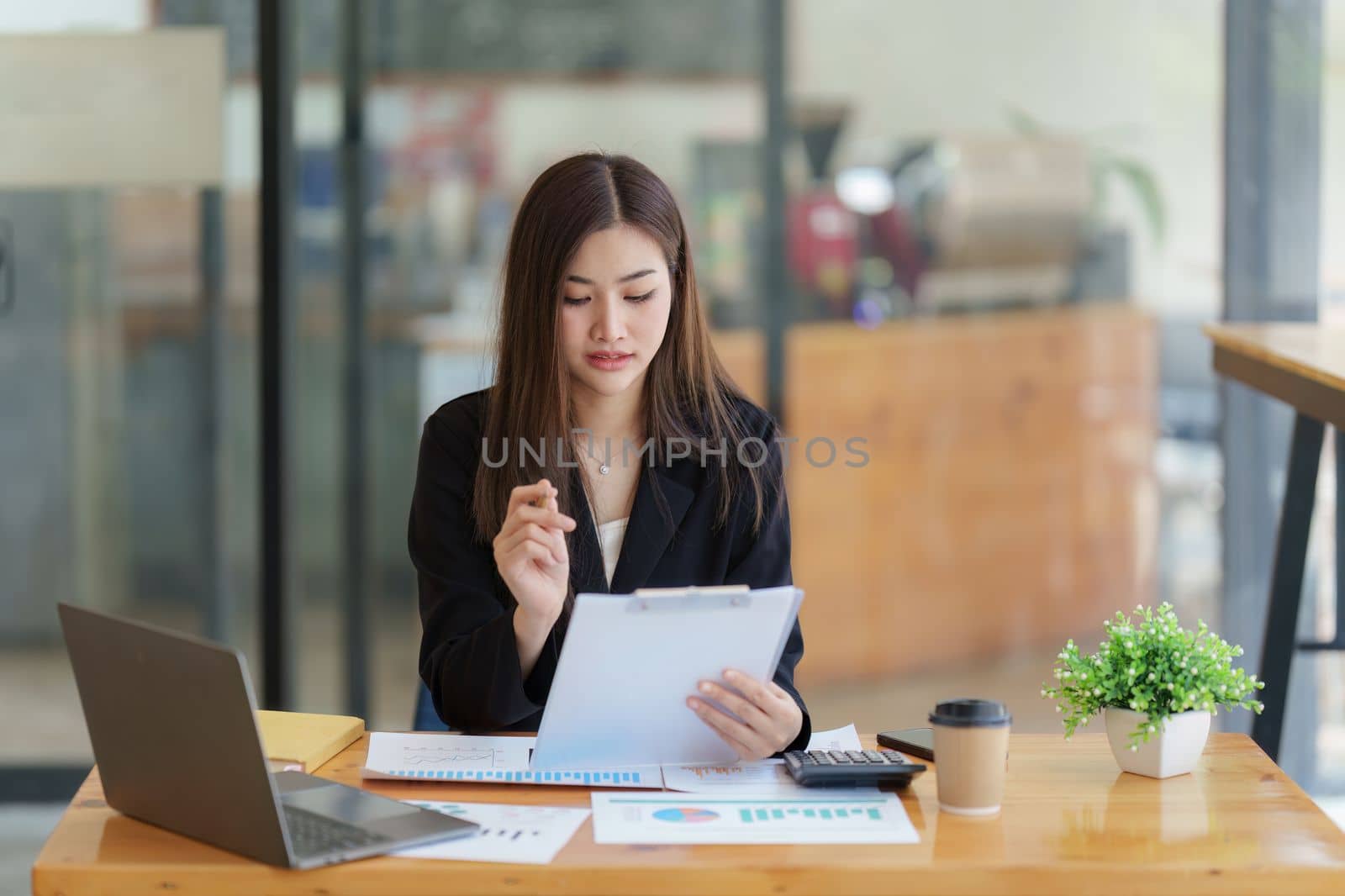 Asian Business woman working at home office and analyze financial report document. Accounting and Finance concept by itchaznong